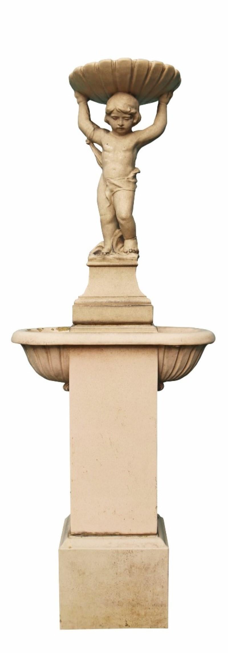 An early 20th century Lefcoware glazed terracotta Bird Bath in the form of a putto holding a scallop shell aloft, standing upon a square plinth with two further basins. This birdbath was one of the most successful designs produced by the Leeds