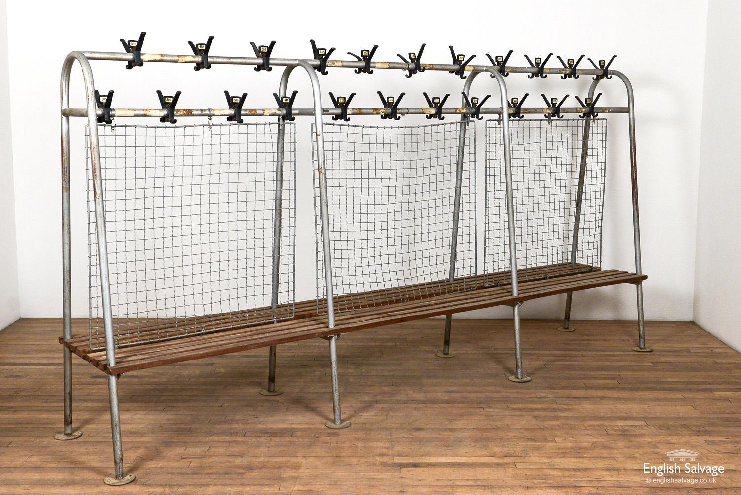 Salvaged midcentury changing room benches in tubular steel with slatted wood seats. Heavy duty wire mesh dividers and early plastic numbered coat hooks. The benches have fixing discs to the bottom each of the eight legs with fixing holes present.