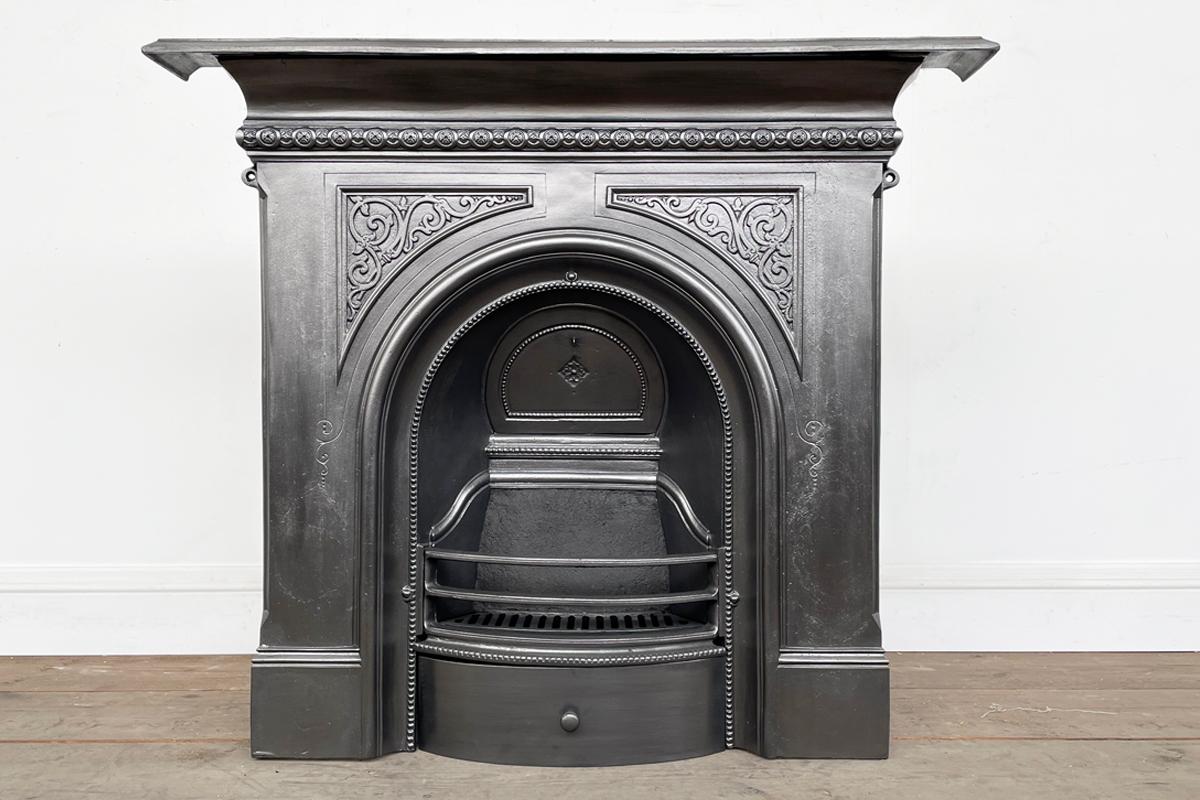 Reclaimed mid-Victorian cast iron combination fireplace with an arched aperture and blind fret detail to the spandrels. Dated July 1880

Ready to be installed and used for a real coal or log fire, this grate has been finished with traditional