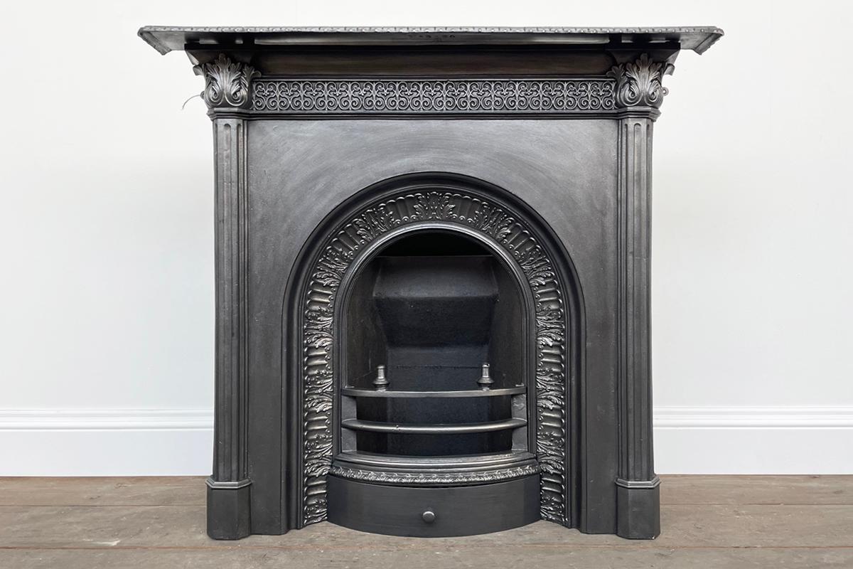 Reclaimed mid Victorian cast iron arched combination fireplace. Circa 1880.

The fluted legs terminate in acanthus leaf capitals which flank delicate blind fret detail, to the frieze. Further flutes and acanthus leaves frame the arched opening.

The