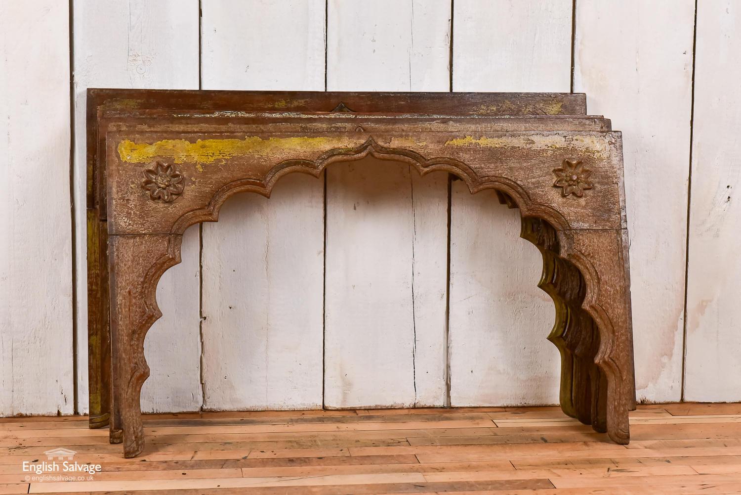 Reclaimed Indian hardwood Mihrab style arches with remnants of yellow paint and a simple flower motif to either side. There are some chips and scratches to the surface of the wood which together with the distressed paint finish, bring an attractive