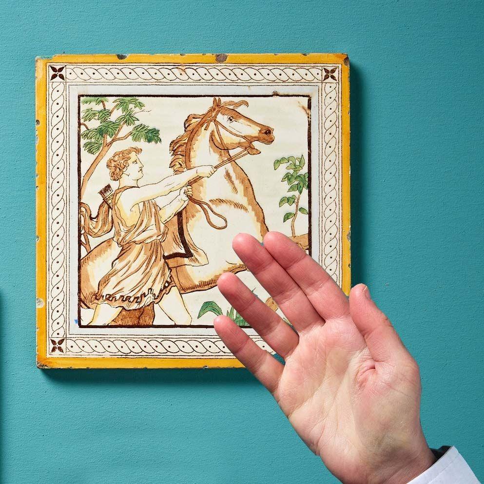 A reclaimed 8-inch clay tile by Minton Hollins & Co. (stamped to reverse) illustrated with a mythological scene from Shakespeare’s 1593 poem ‘Venus and Adonis’. Inspired by Greek mythology, the poem tells the story of Venus, the Goddess of Love, and