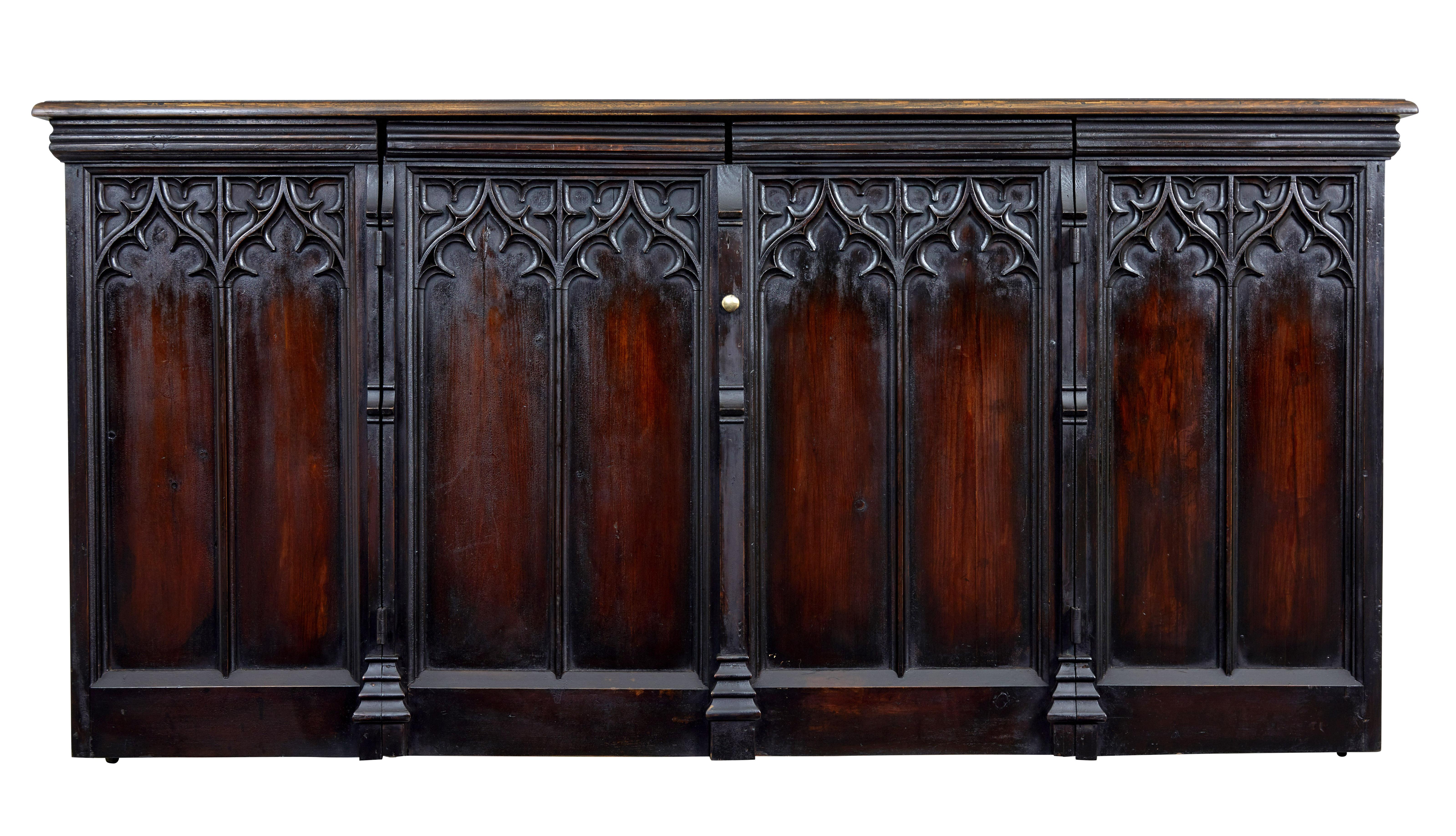 We are pleased to present this unusual piece made from reclaimed church pews.

Using the tracery and elements from church pews has allowed the maker to turn this into a sideboard. 4 panels to the front with the middle 2 opening to reveal a single