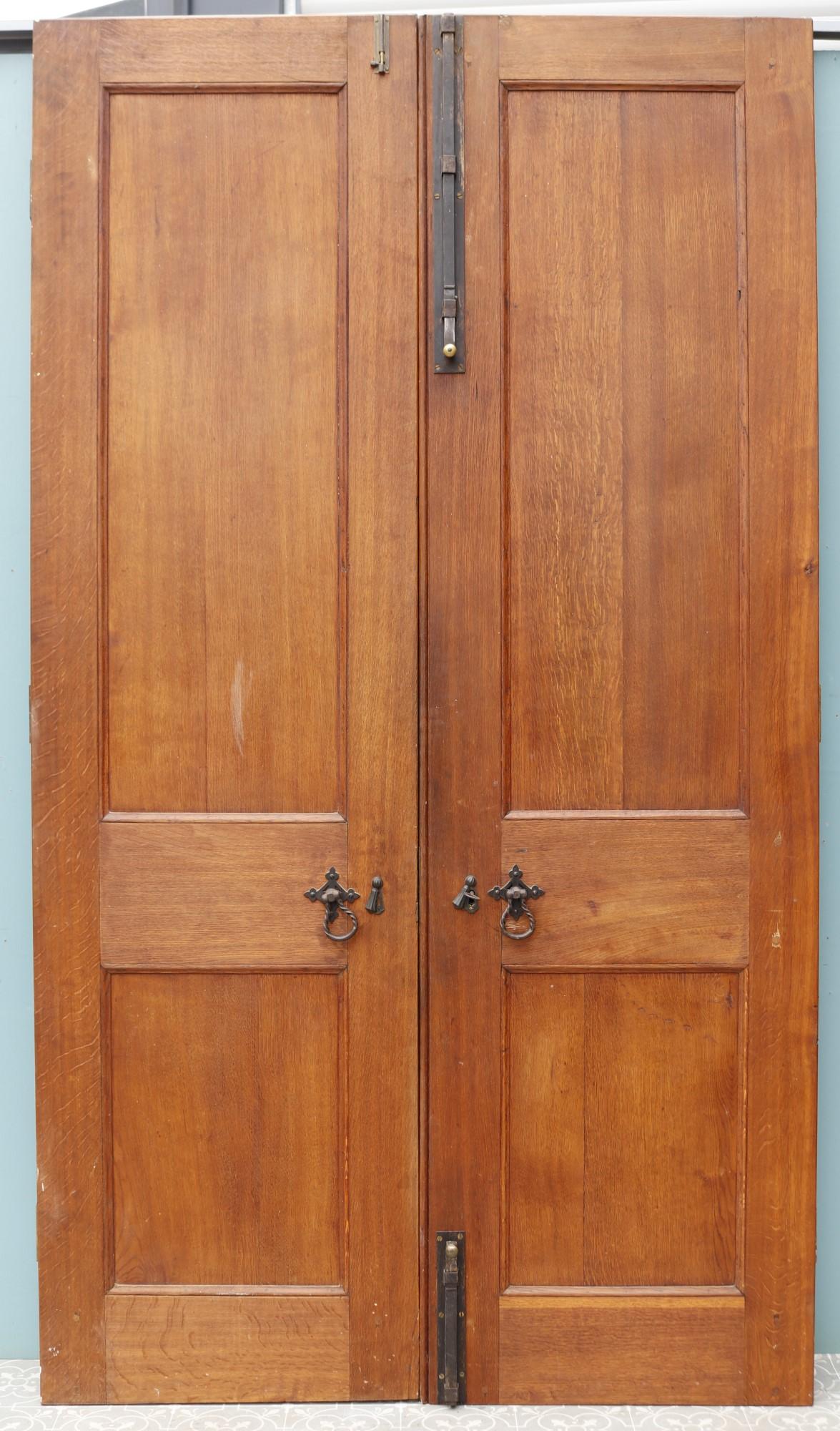 A set of antique double doors constructed from oak with raised and fielded panels.
