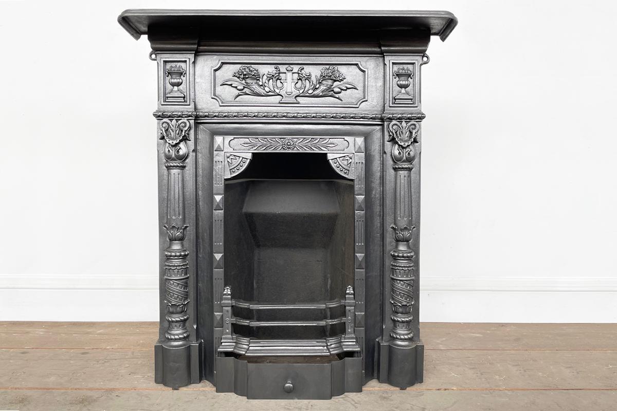 A reclaimed ornate late Victorian cast iron bedroom combination fireplace. Circa 1885.

Fully restored and finished in a traditional black grate polish and supplied with a new clay fireback, cast iron bottom grate and steel ash cover.

For