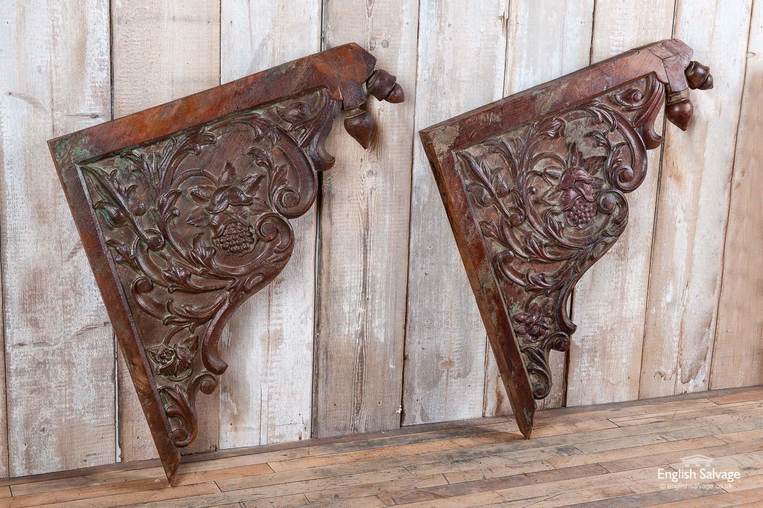 Salvaged ornately carved teak brackets with fuit and foliate design. The top front corners have double finials. The wood has an attractive patina with subtle paint on the flowers and fruit. The brackets appear to be in very good condition, with one