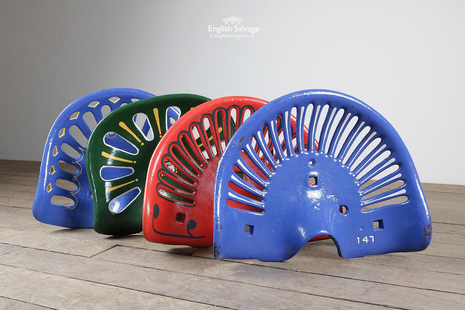 Original cast iron tractor or implement seats gloss painted with contrasting accent colors. Sizes vary slightly, blue and yellow seat measurements are below. Green and yellow 39.2cm W x 10.5cm H x 34.5cm D, red and blue 42.6cm W x 9.5cm H x 34.5cm