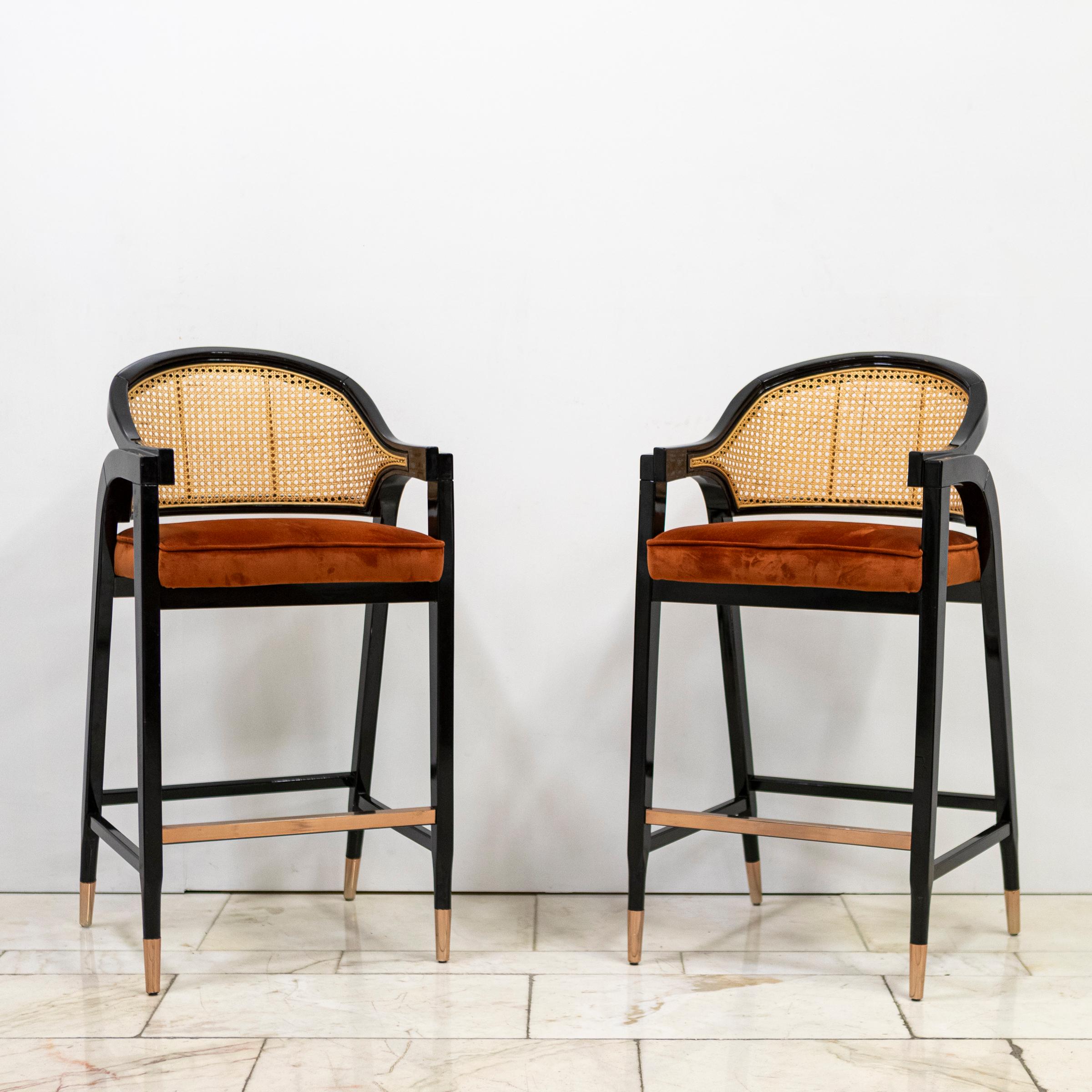 Una coppia di sgabelli da bar di grande effetto, con struttura in legno dalle linee fluide, ispirata all'America di metà secolo. Un design raffinato in omaggio a Edward Wormley, figura di spicco del movimento modernista, famoso per aver trasformato