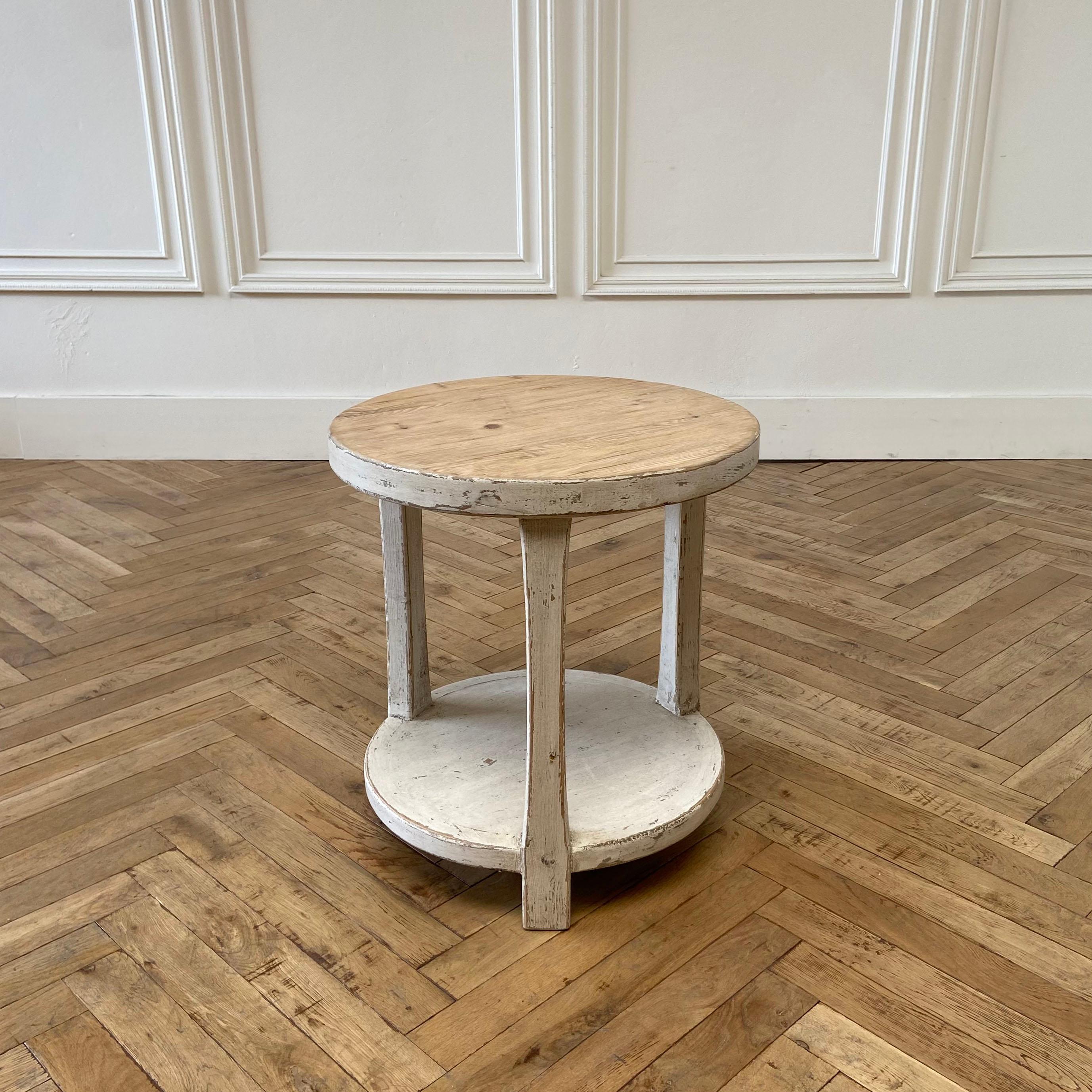 Reclaimed pine round side table with white painted legs. Round side table with shelf, painted distressed white legs. The table top is natural with a hand scraped top. 

Size: 22” W x 22