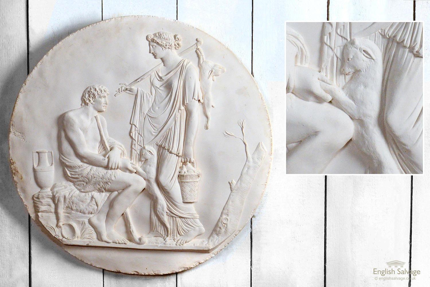 Impressive antique chalk relief moulds depicting Classical Greek pastoral scenes. One shows a Greek couple milking a goat, another a mother teaching a child to play a trumpet, and the third a scene with a huntress and her companion with a dog. There