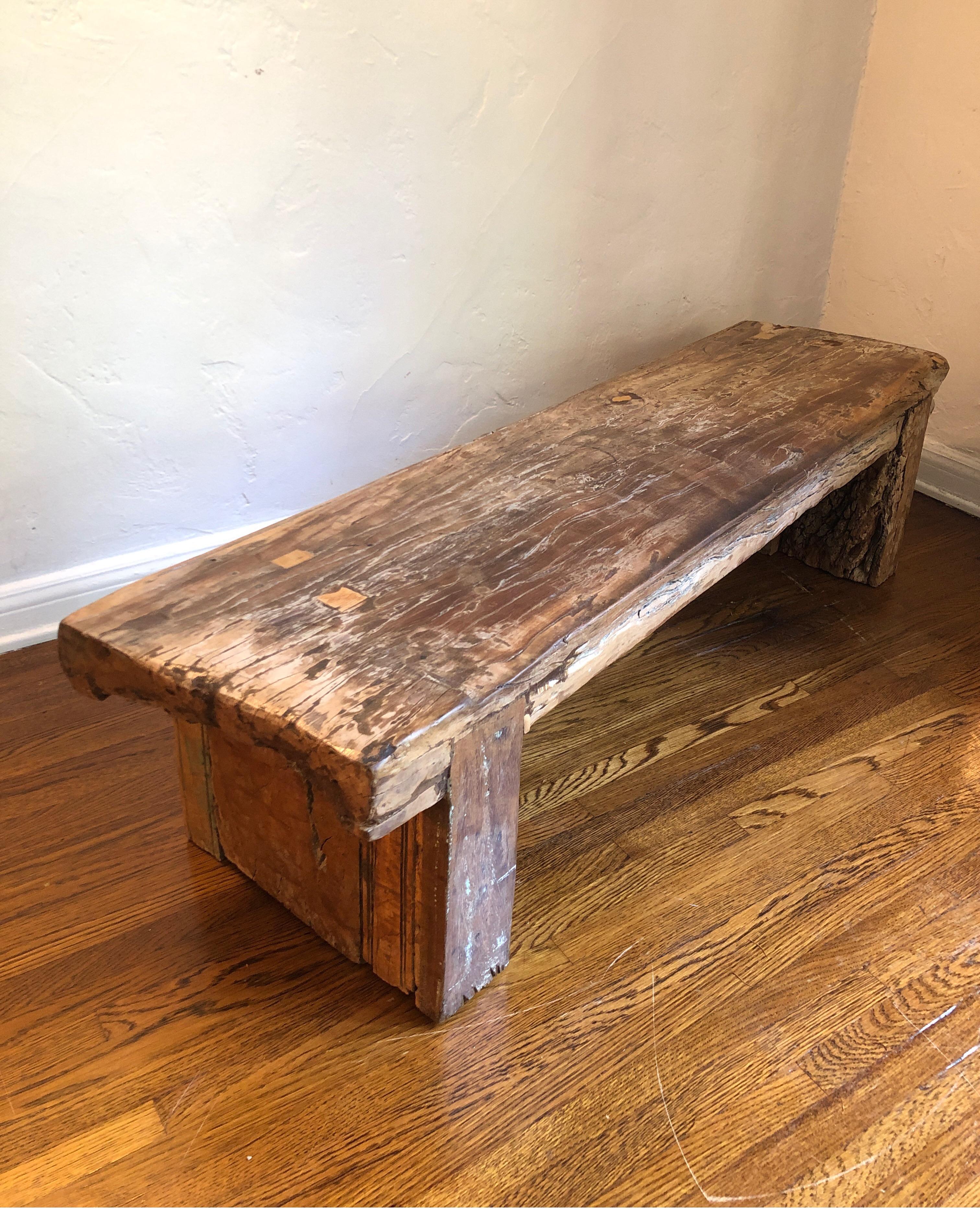 Very solid and heavy piece. Thick reclaimed wood log (possibly teak) turned into Primitive style modern bench.
Gorgeous veins with a petrified wood look. This is very old wood, but we believe it to be made more recently. Very heavy.

Entry bench