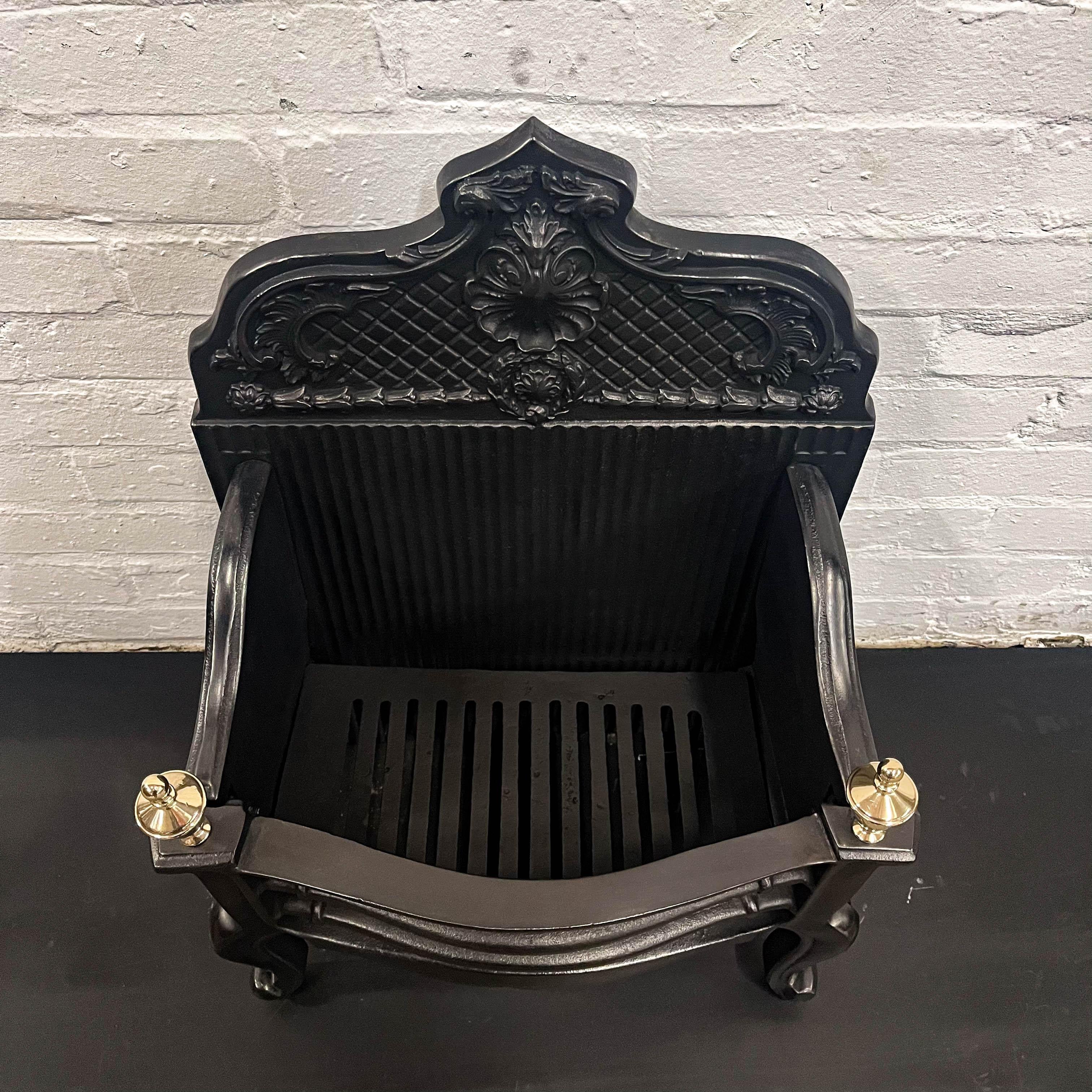 The tall backplate of this reclaimed fire basket features ornate, deep profile motifs.

The elegant cast-iron piece has elegant brass finials and has been fully restored and is ready for installation and use. A bespoke gas kit can be provided,