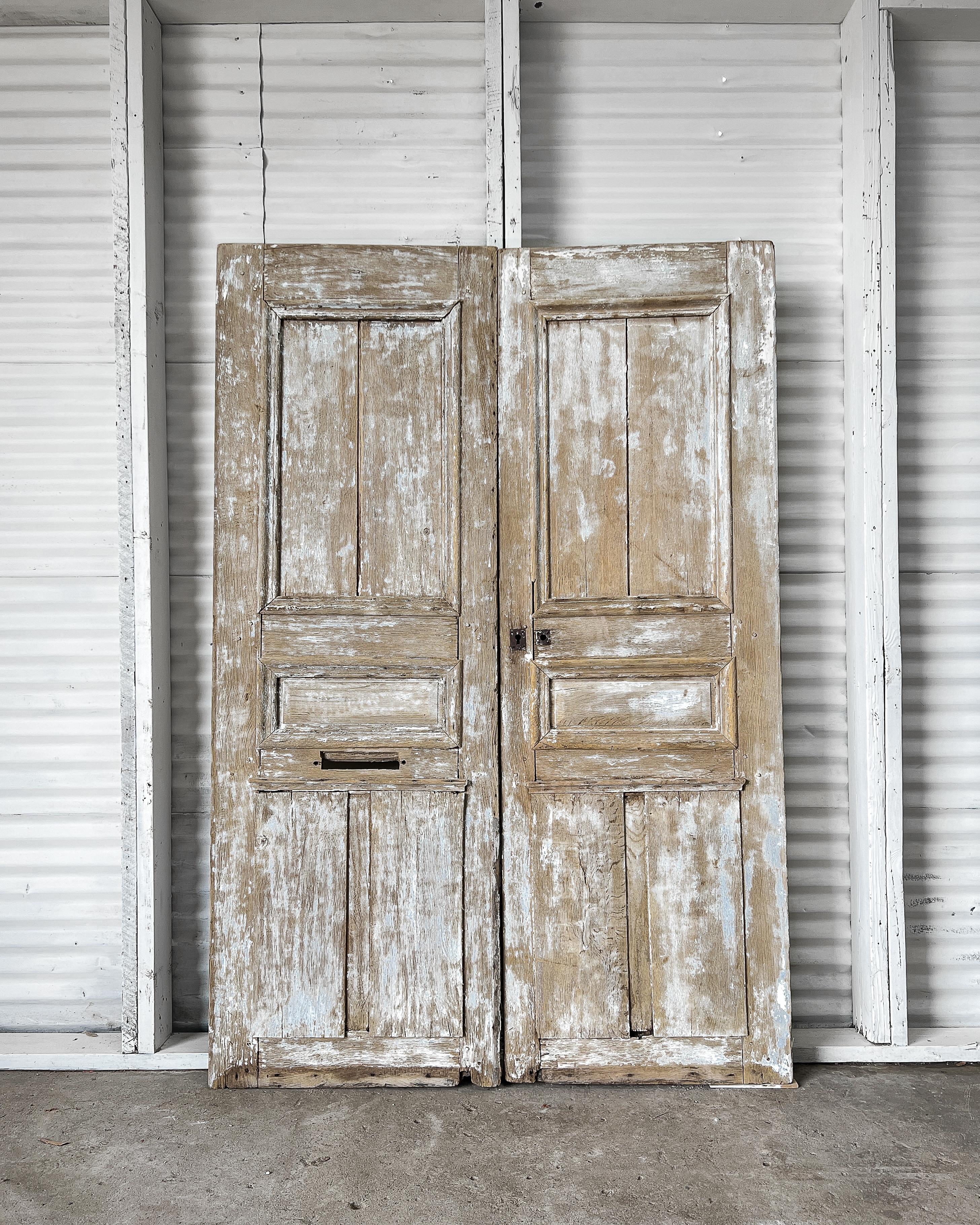 Reclaimed solid oak raised panel exterior doors with a rustic, weathered appearance. Once gracing a beautiful French home, these doors will add character and old-world charm to your modern home whether installed on the exterior of your home or used