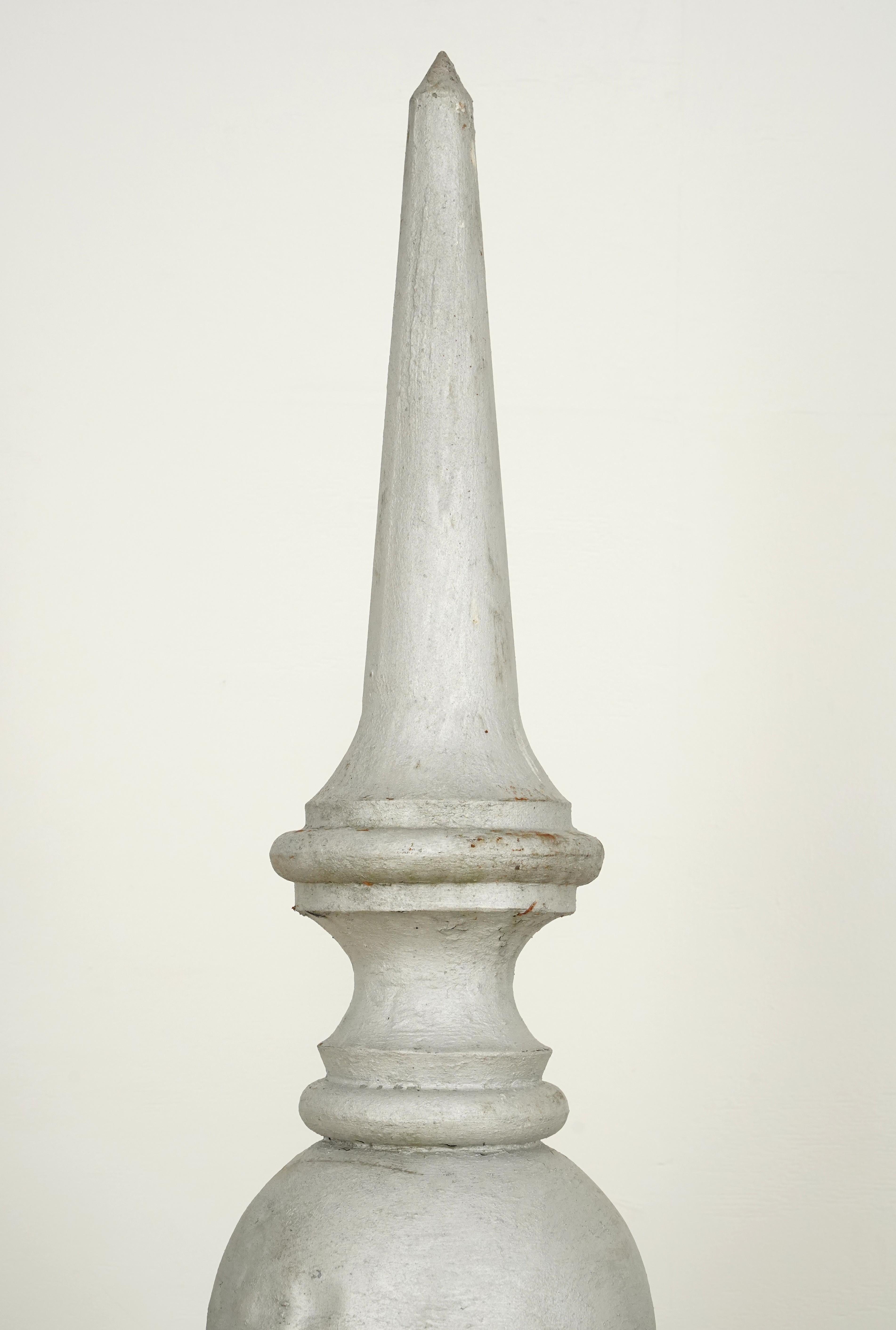 Reclaimed late 1800's rooftop finial made of steel with a painted gray finish. Now mounted on wood. It has a multi-tiered design with a round ruffled base, a bulbous middle, and a pointed top. There are visible signs of age and wear, such as slight