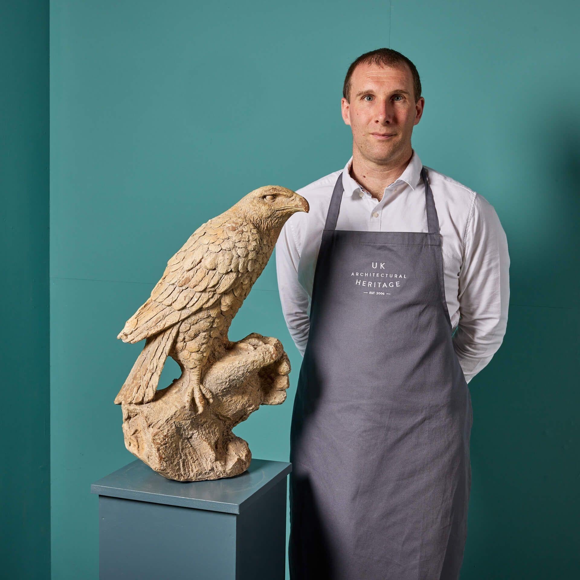 A reclaimed model sculpture of a bird of prey perched on a hand. At twice life size scale, this mid 20th century sculpture is an impressive decorative piece, with details of its wings, beak and face still beautifully carved in great detail. It is