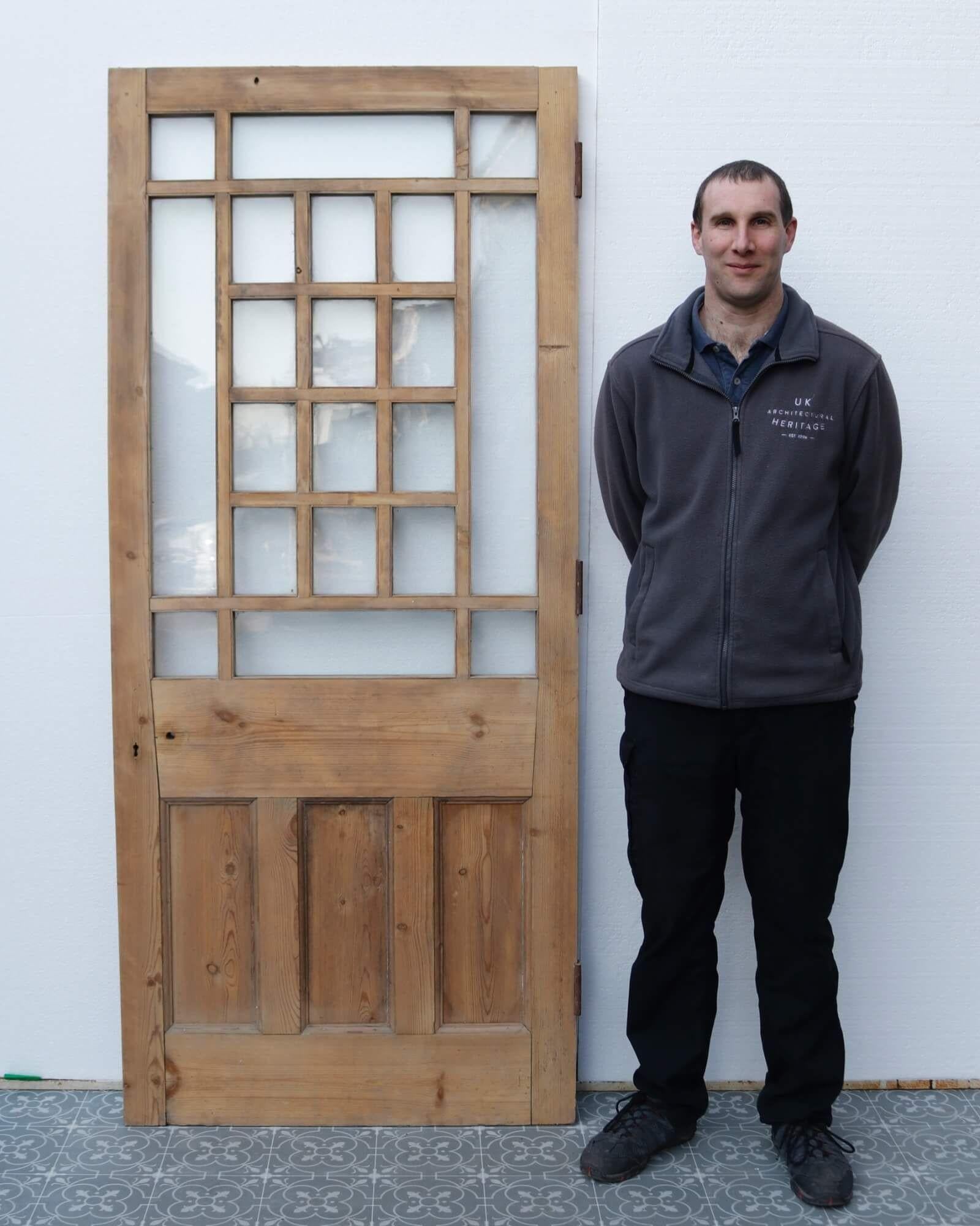 With its unusual glazing pattern, this reclaimed Victorian front door is a striking feature for the entrance or interior of a late 19th century or early 20th century property. It is constructed in pine with three vertical panels to either side below