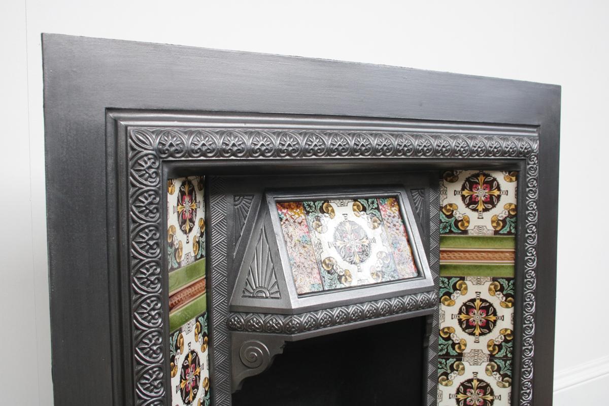 The Stanley, a reclaimed Victorian tiled fireplace grate, with a tiled canopy, circa 1890. Complete with an original set of antique fireplace tiles.
The cast iron has been finished with traditional black grate polish and is supplied with a new