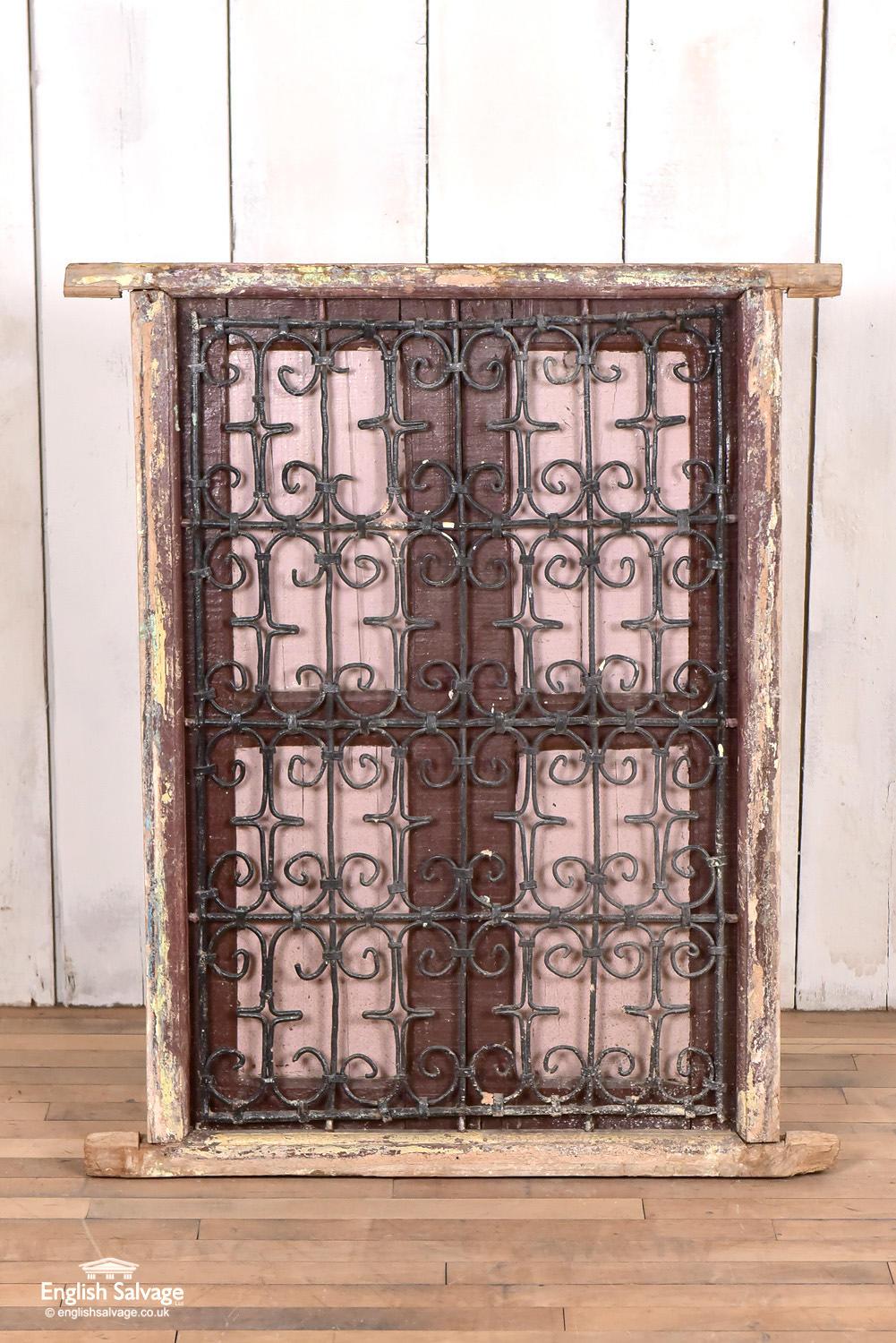 Simple painted antique North African window with wood shutters behind a wrought iron screen. The windows are quite crude and have tatty paint. The dimensions of 70cm wide x 1010cm high exclude the projecting lugs on the side of the window. The