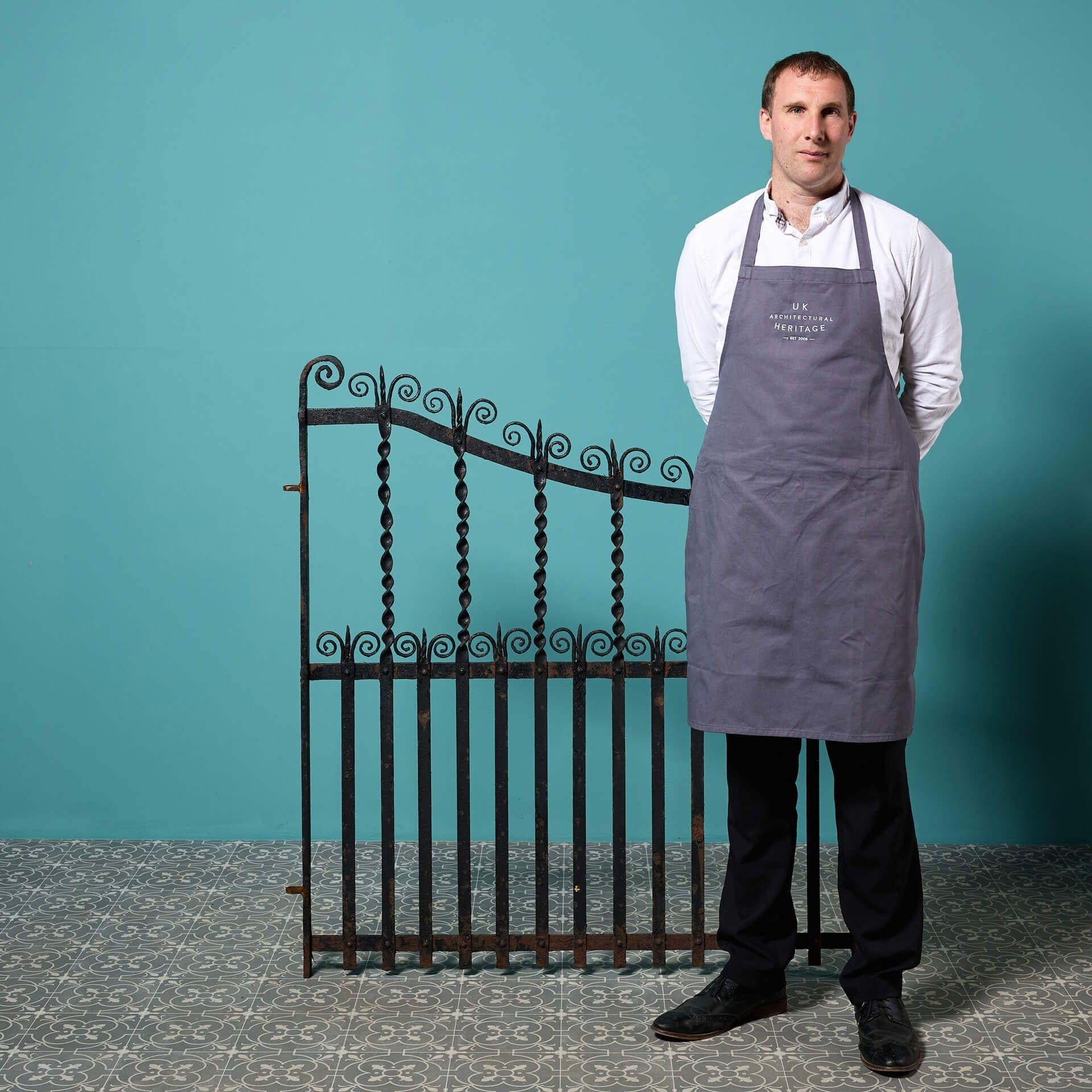 A blacksmith-made wrought iron garden side gate, reclaimed from a house in Birmingham. With its gently sweeping arch, twisted rails and ornate scrollwork, this antique pedestrian gate is a timeless addition to gardens of any age or style.

Second