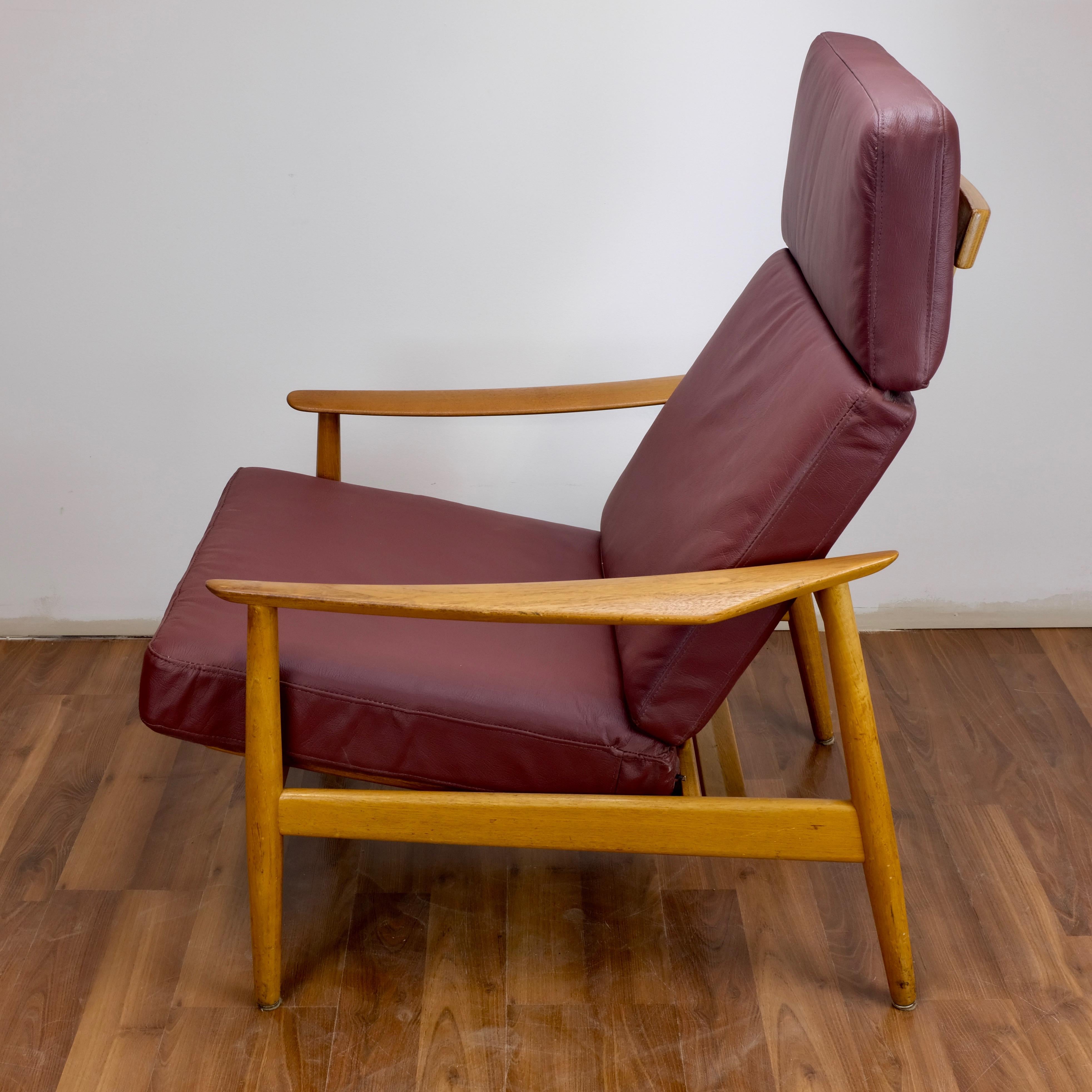 France and Søn model 164 armchair designed in 1960 by Arne Vodder.

The solid teak frame has been refinished and the loose cushions have been reupholstered in burgundy faux leather.

The seat and back can be adjusted to recline in three