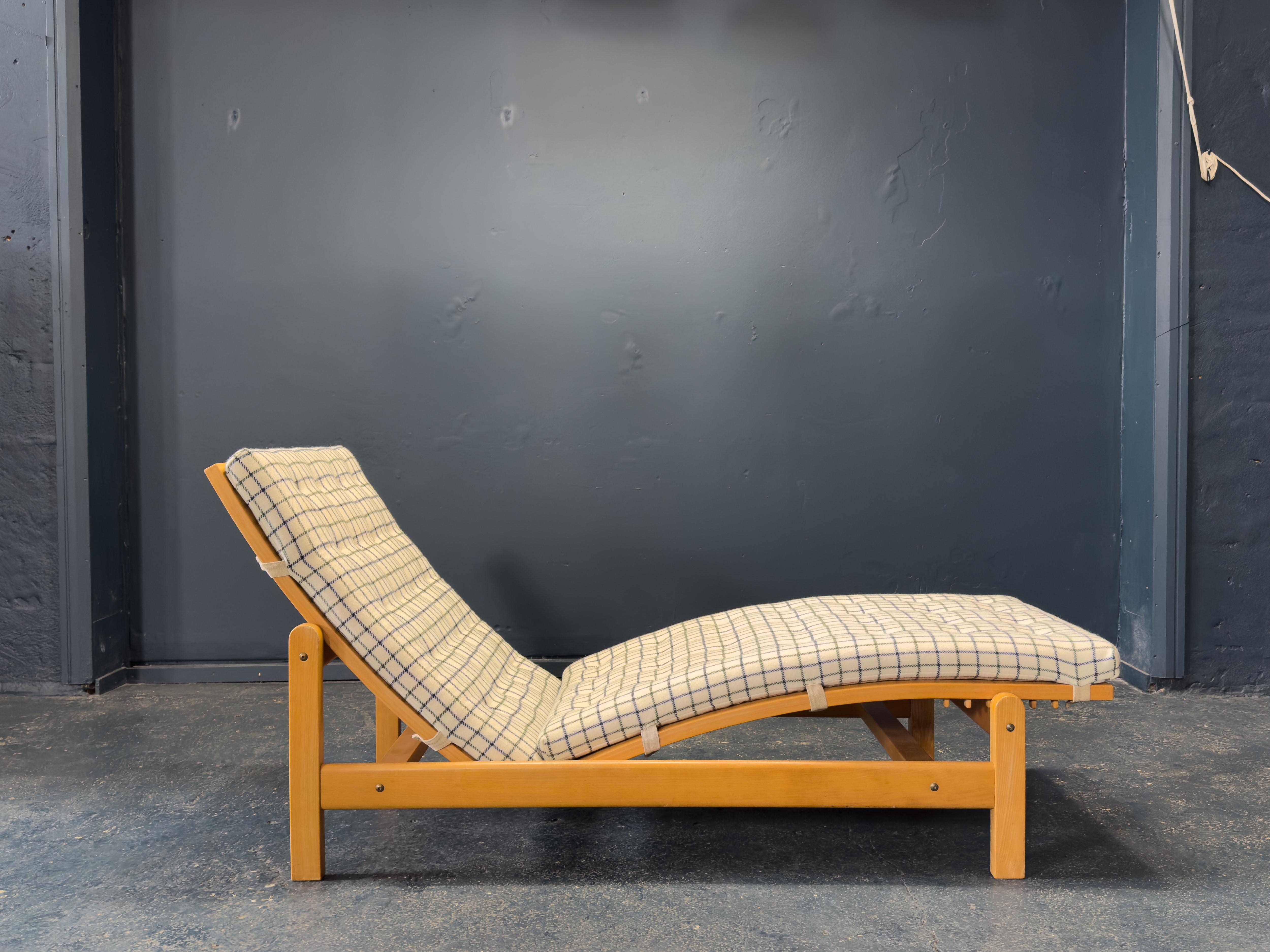 Diese verstellbare Liege ist ein Meisterwerk des modernen, funktionellen Designs, das Komfort, Schlichtheit und skulpturale Form miteinander verbindet. Der sanft geschwungene Rahmen ist aus Massivholz mit natürlichem Finish gefertigt, so dass die