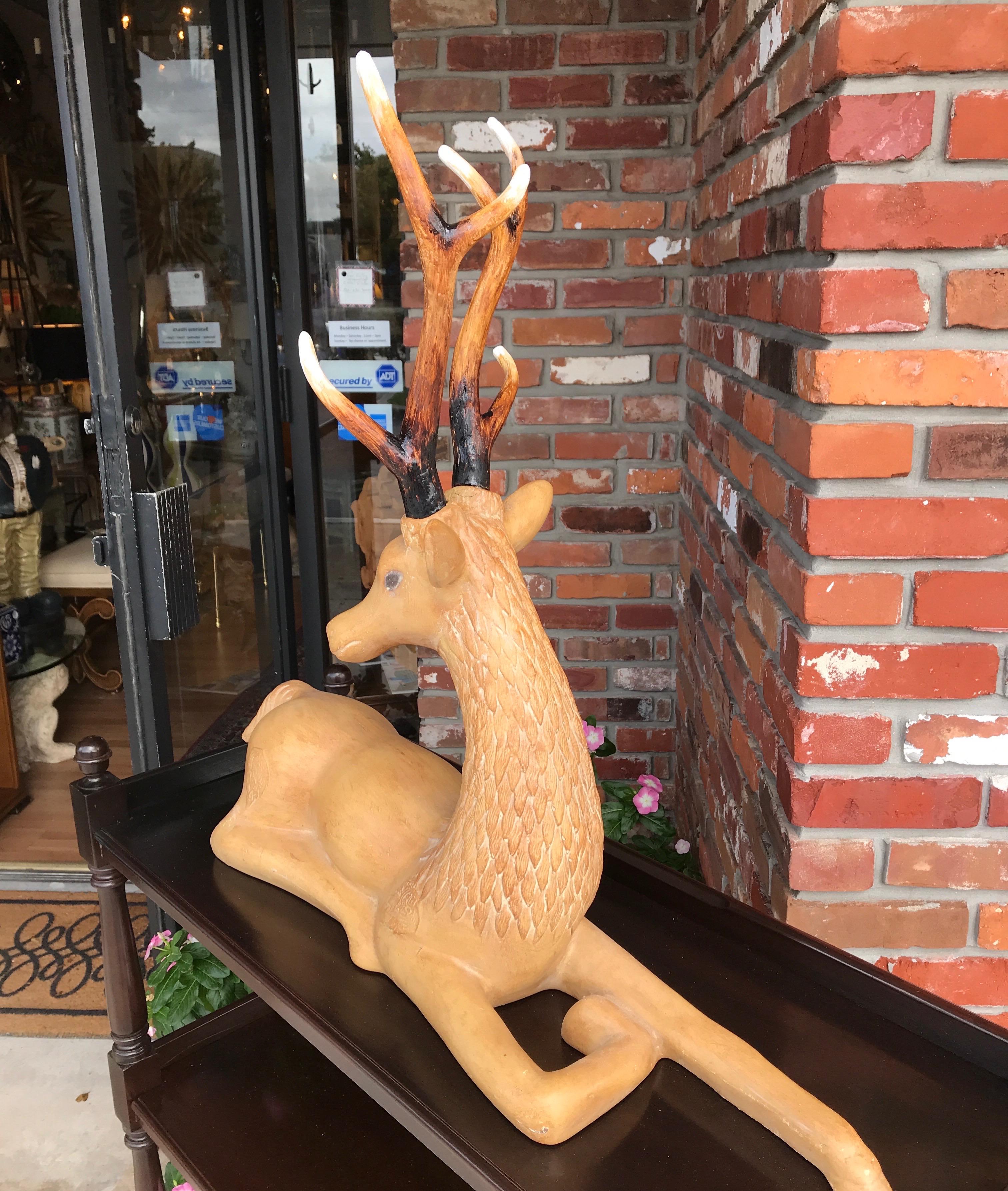 Reclining deer with removable antlers.