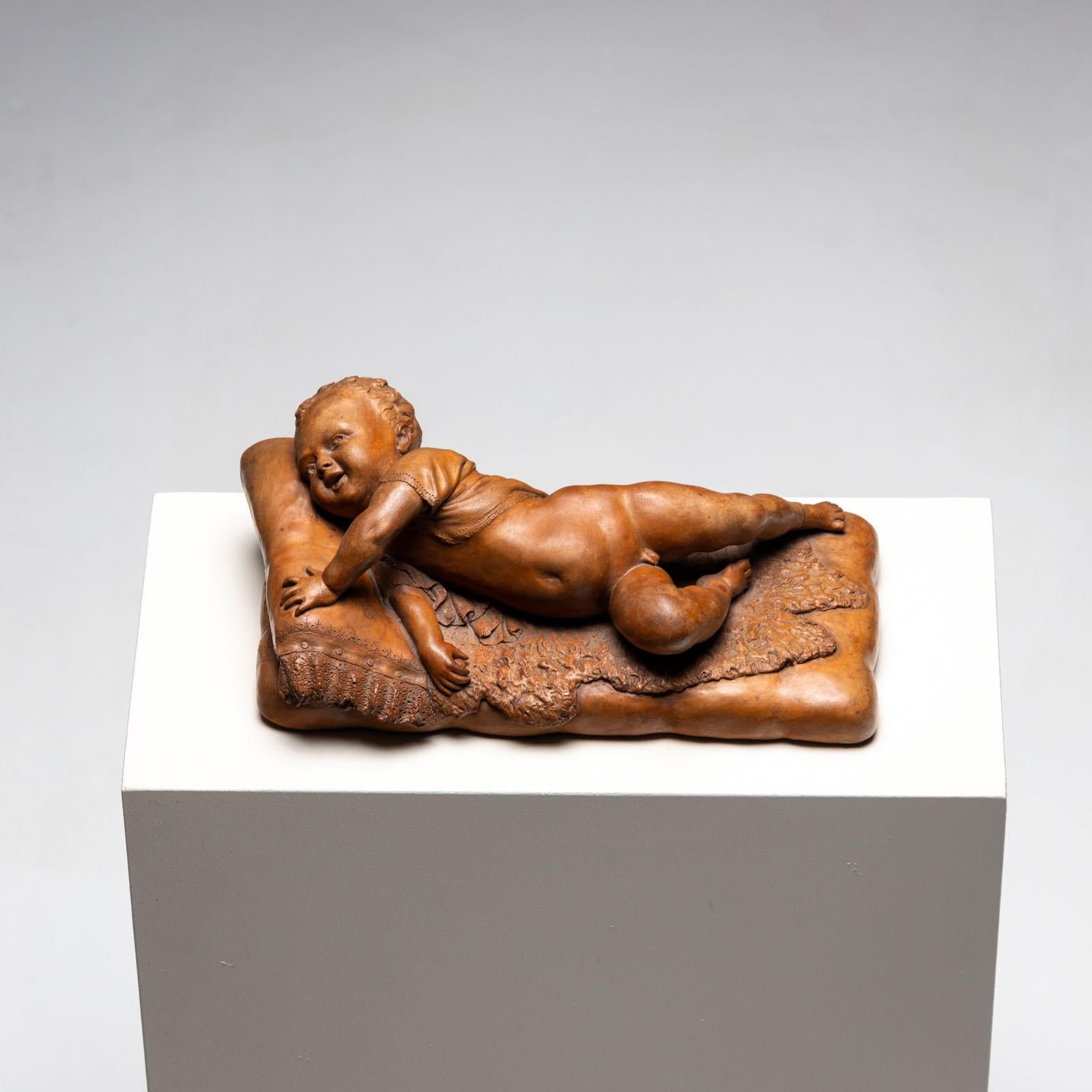 Small terracotta of a lying infant on fur and cushion with lace border. Signed at the head 23 No. ... 92, F. SANS.