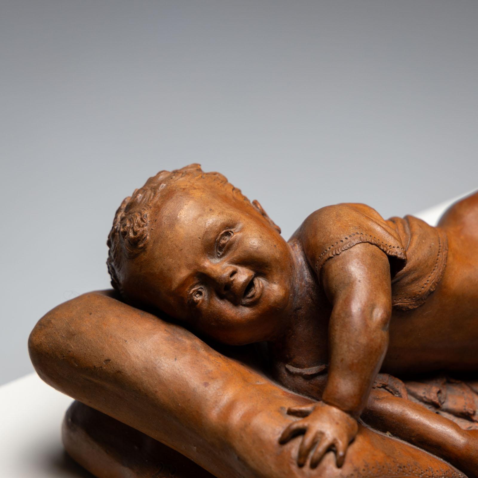 Spanish Reclining infant in terracotta, sign. F. Sans, probably Spain, Late 19th century For Sale