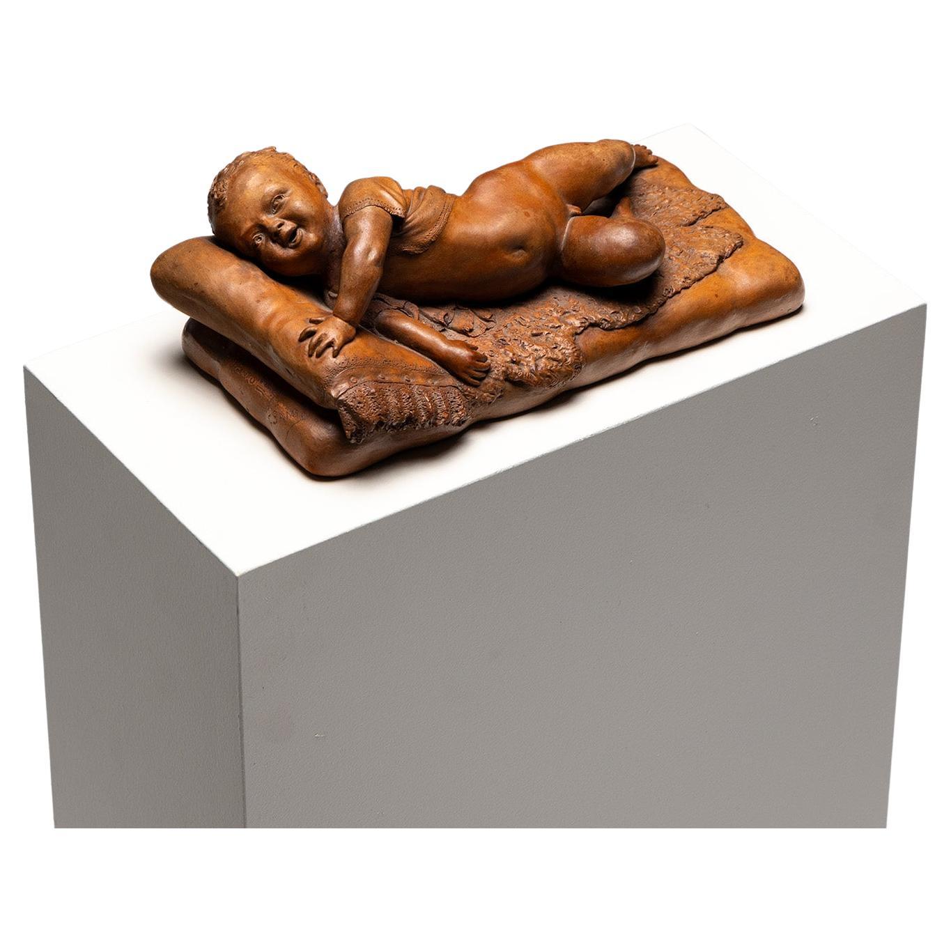 Reclining infant in terracotta, sign. F. Sans, probably Spain, Late 19th century For Sale