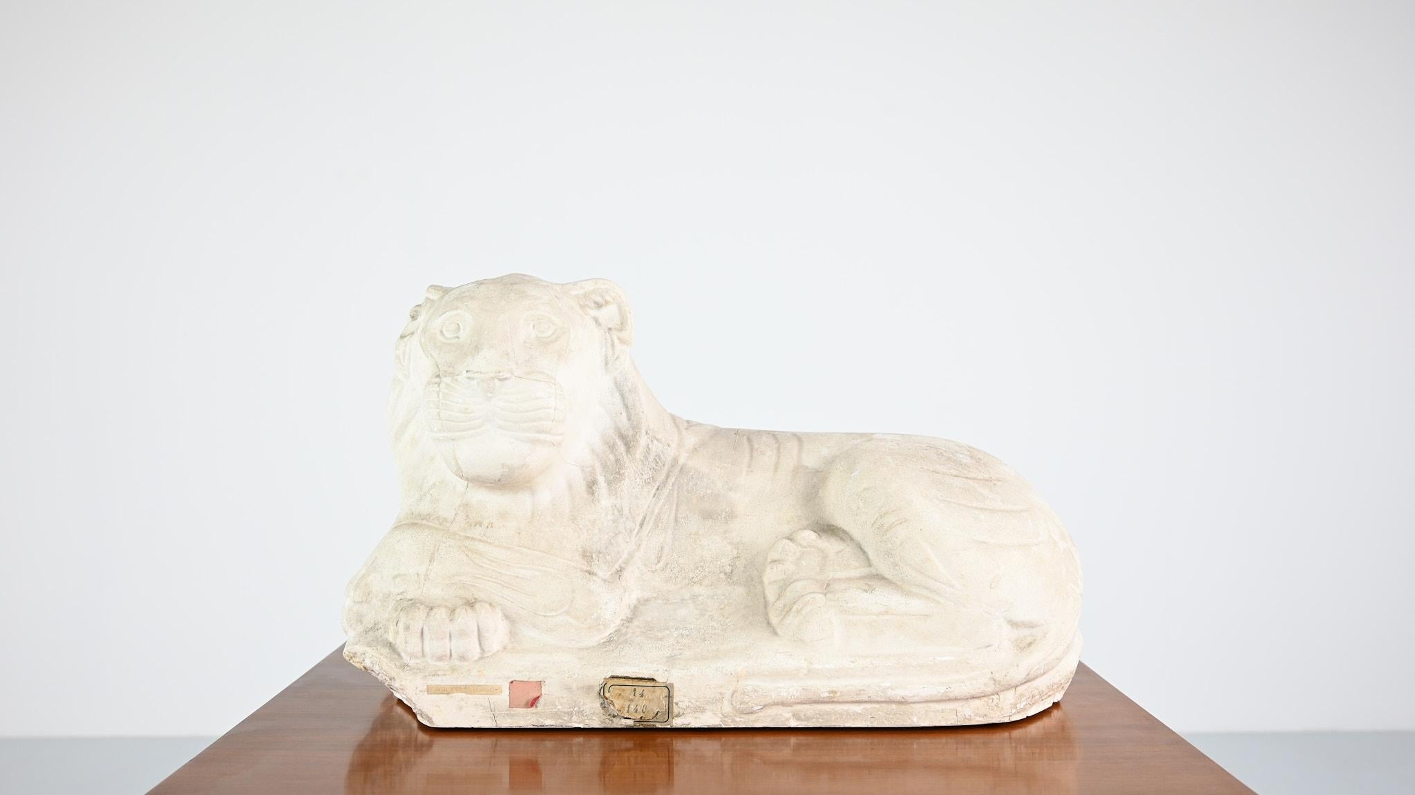 Reclining lion, vintage 1:1 reproduction in plaster, most likely from Les Ateliers d’Art des Musées nationaux, of the “Lion couché”, a basalt sculpture found in Byblos or Beyrouth, from the Achaemenid period, circa 400-300 BC, and part of the