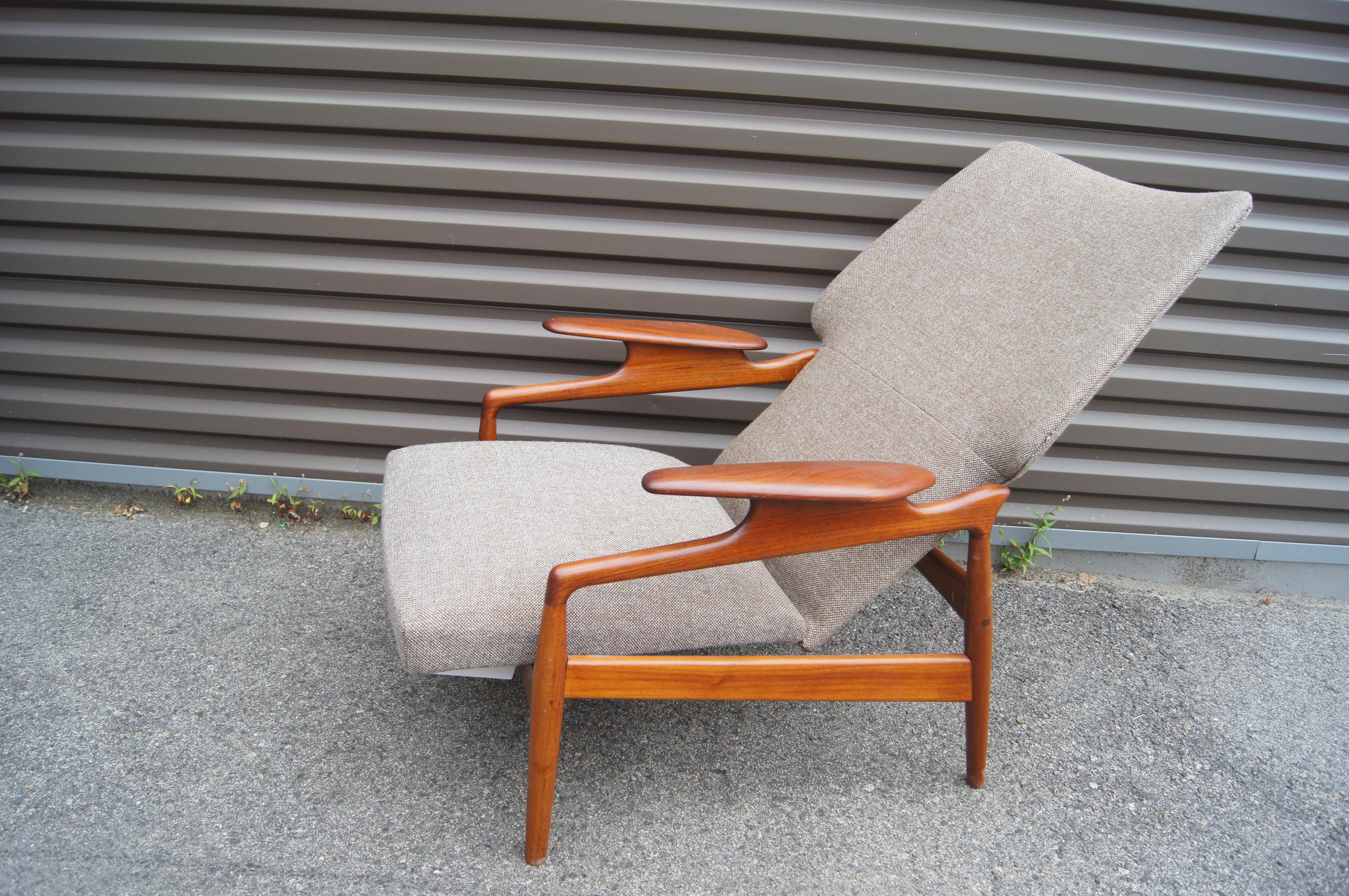 This 1960s teak lounge chair, by the Danish designer John Boné for Advance Design, adjusts from an upright to a reclining position. It features a gently curved wing-back profile and sculptural armrests. The chair has been refinished to bring out the