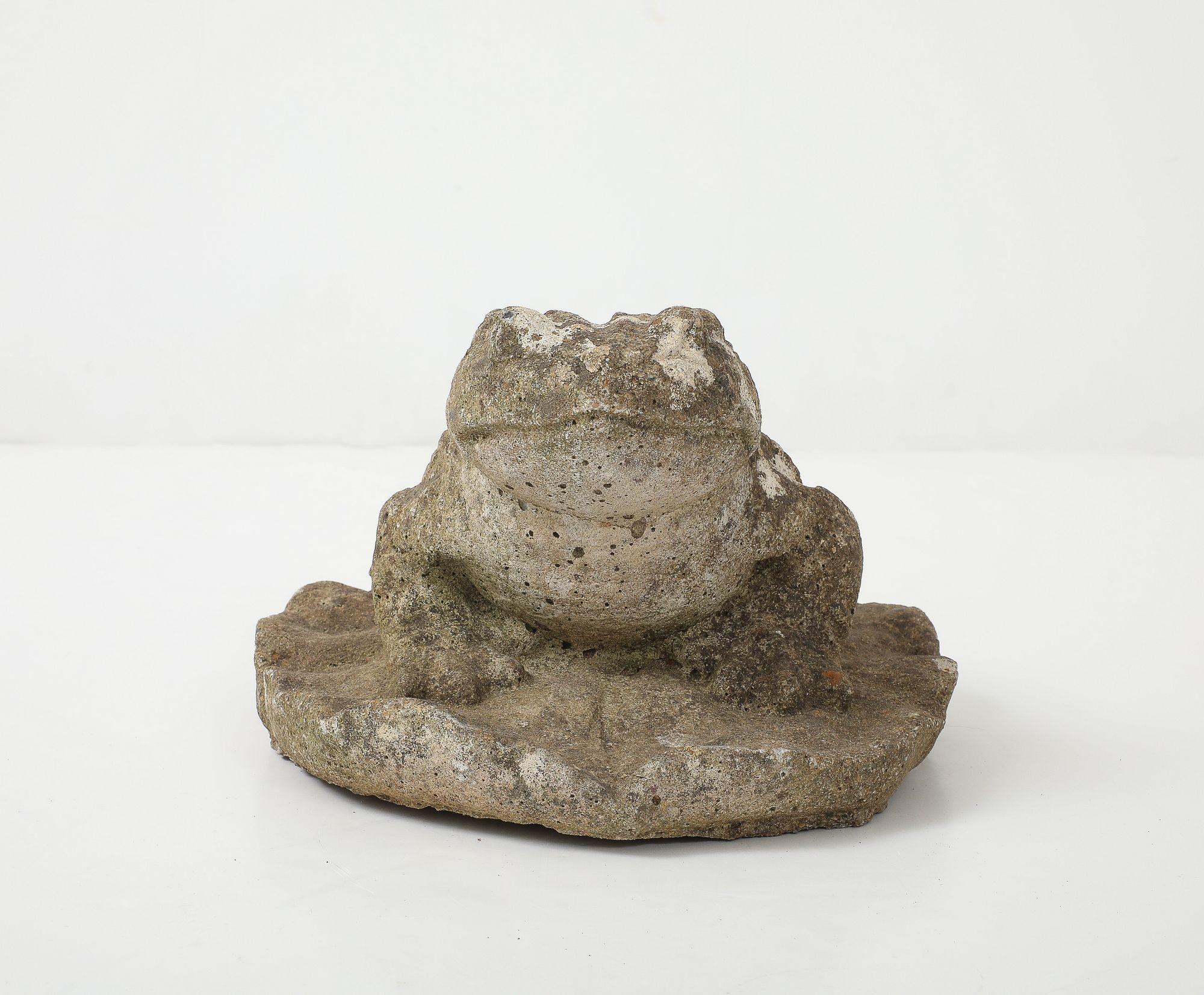 Cette ravissante grenouille de jardin en pierre reconstituée apporte une touche de fantaisie et de charme à votre espace extérieur. Cet ornement présente une patine honnête, qui lui confère un aspect authentique et vieilli, et est tacheté de mousse