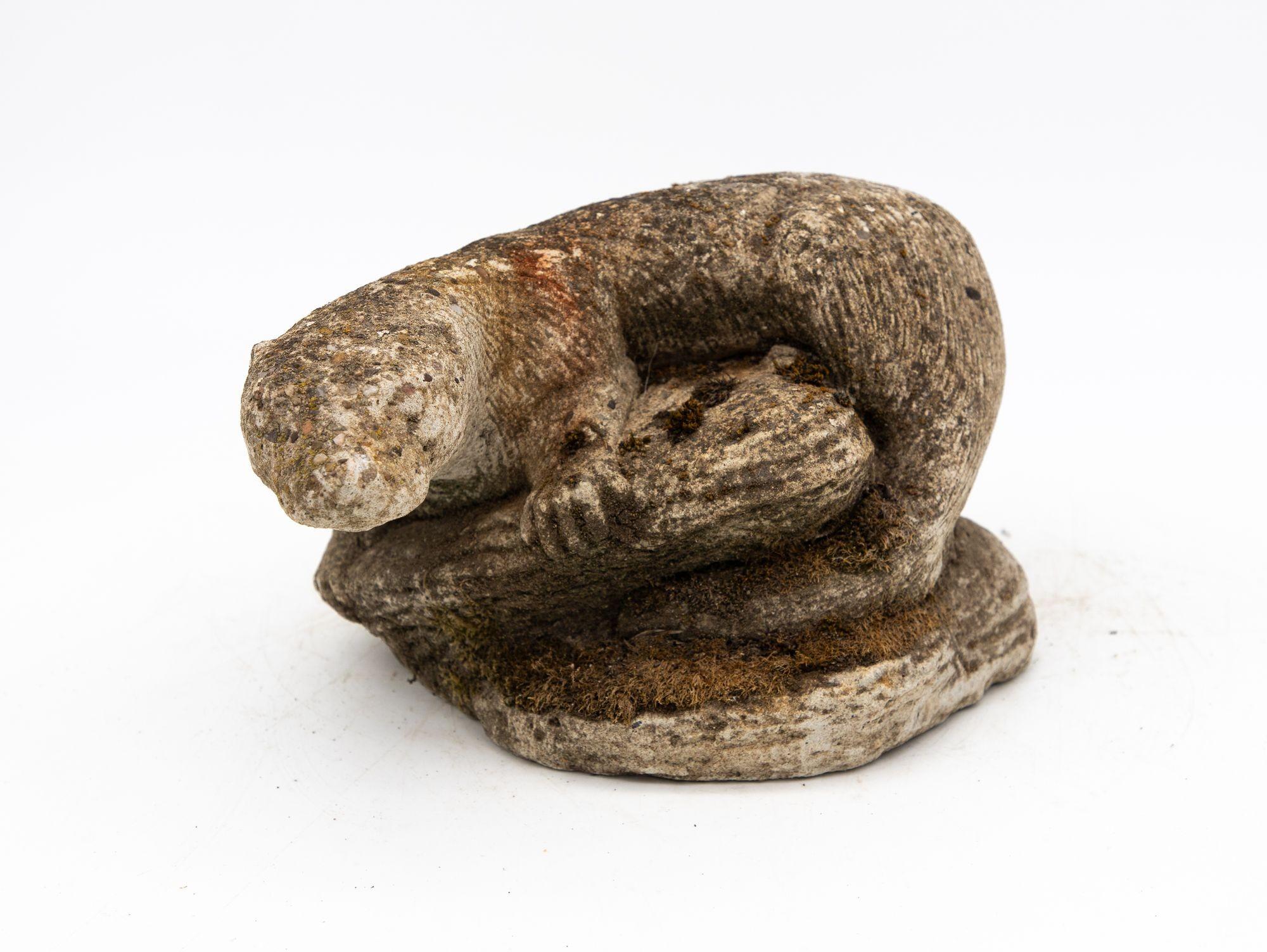 A mid 20th century cast stone French garden ornament in the shape of an otter atop river rocks. The lifelike detail in the coat and the face make for a wonderful example of a classic French garden ornament. The weathered surface and natural growth
