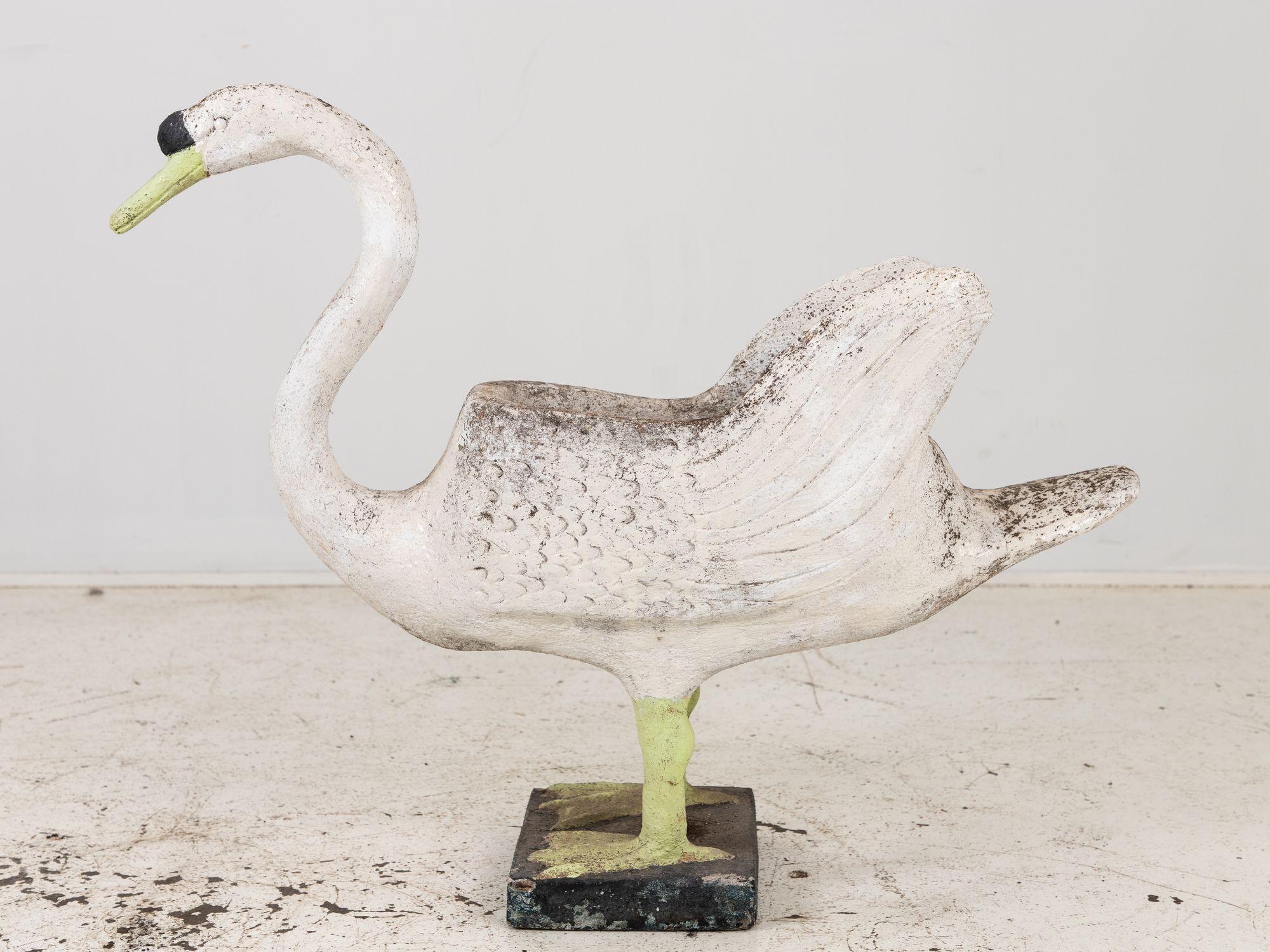 This exceptional Mid 20th Century concrete swan planter on raised feet embodies both beauty and functionality in a single piece. With its graceful curved neck and elegant form, it effortlessly captures attention and adds a touch of sophistication to