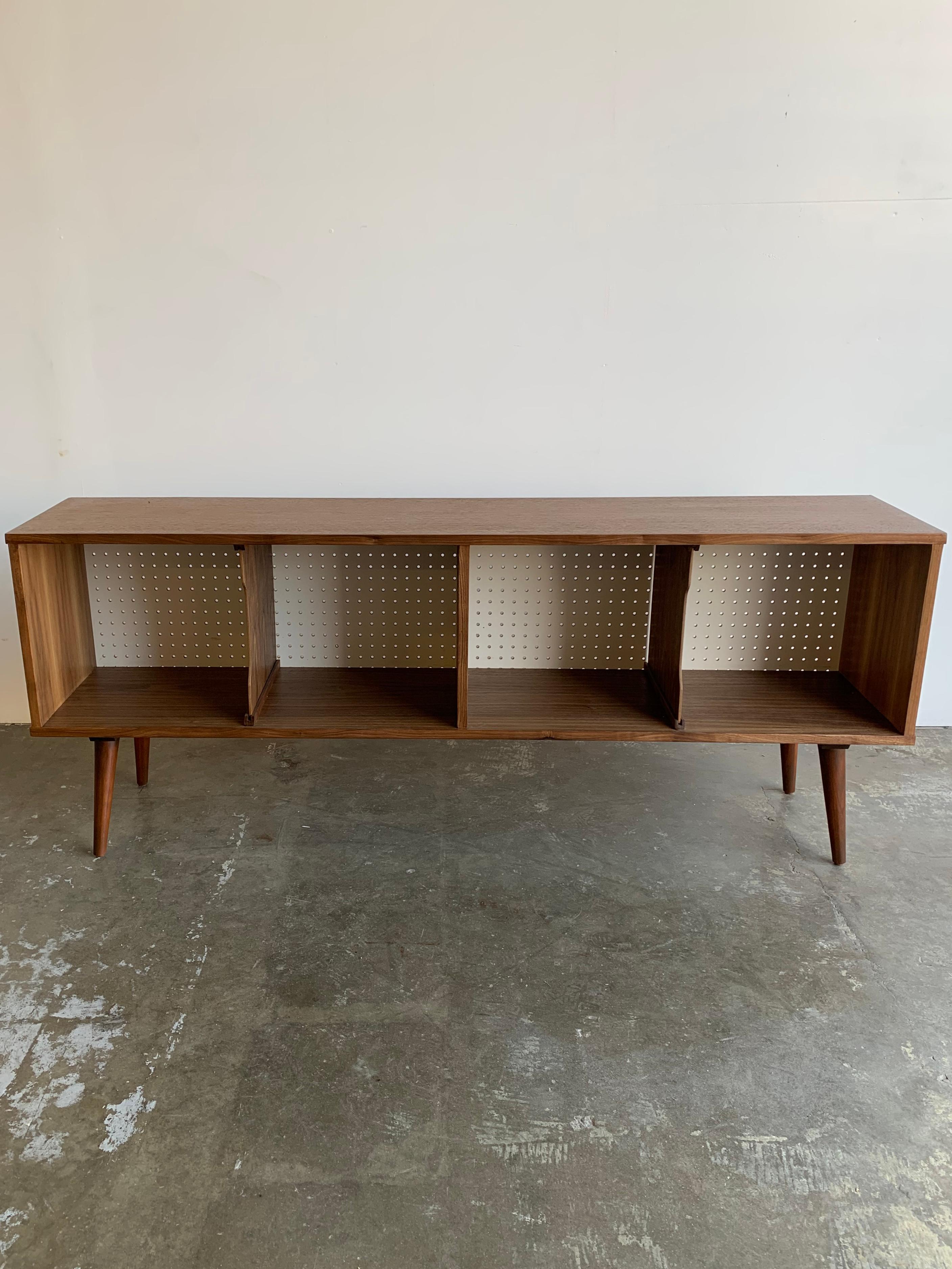Wonderful gently used walnut bookcase or record holder. Divider are removable perforated back is a think lightweight material making it easier for media home to be cut if needed.

This item was hand crafted and used in our staging service for a