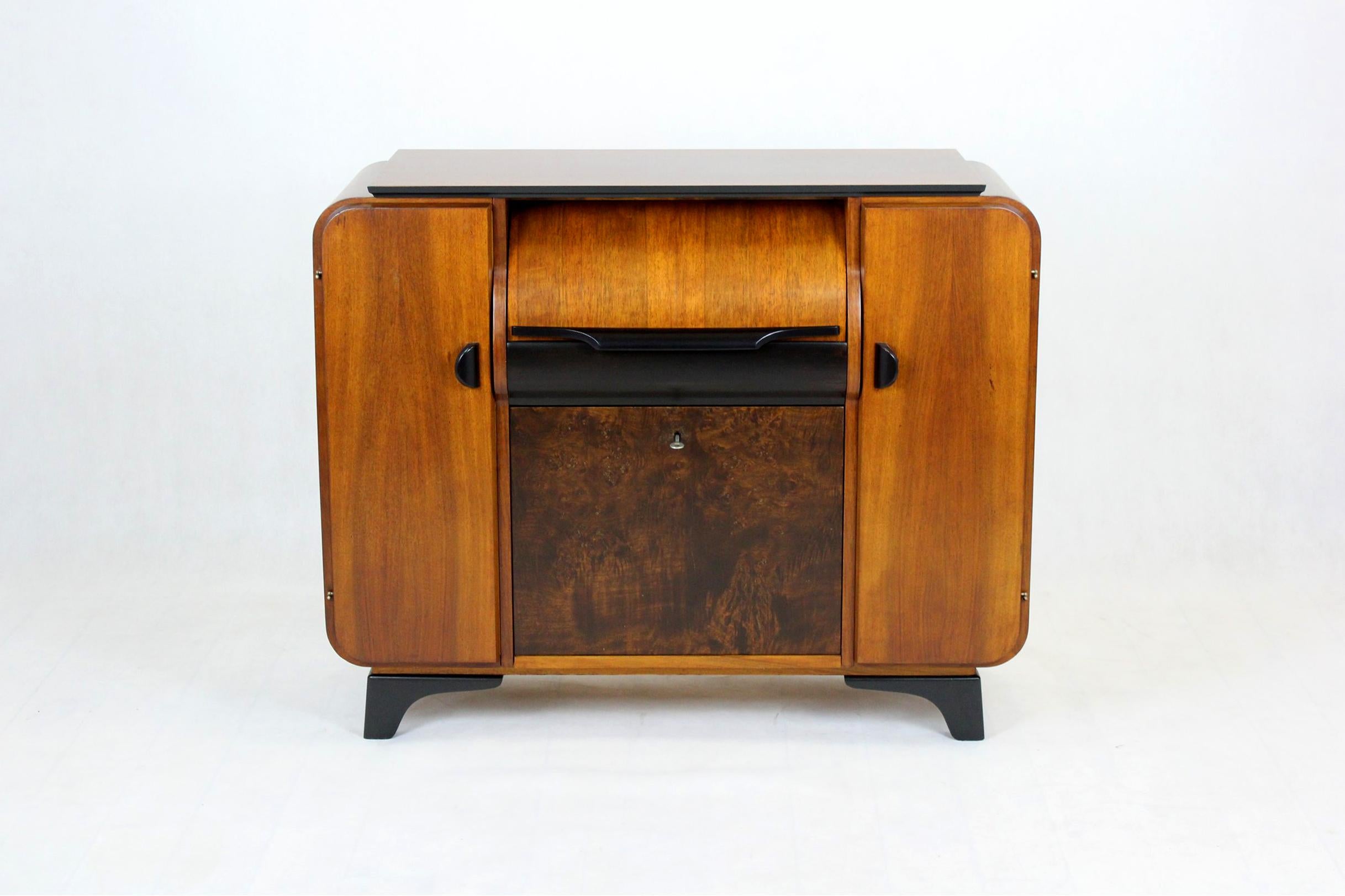 Record cabinet in walnut, designed by Jindrich Halabala and manufactured by Supraphon in 1958. Contains a lot of shelves for gramophone records. The record player is placed behind the flap. The cabinet is kept in very good condition, has been