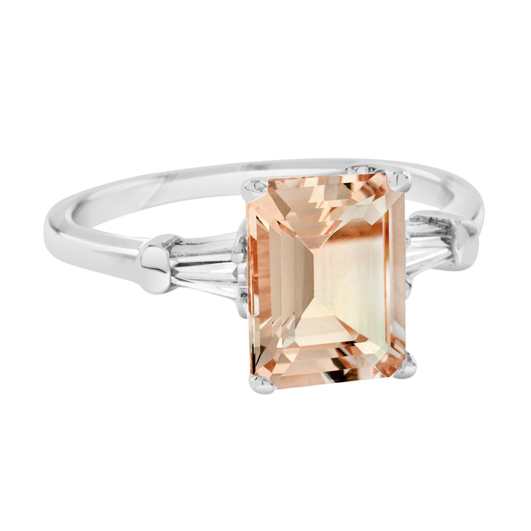 This beautiful ring has a single 9×7 mm. natural morganite with traditional emerald cut, prong-set in an elegant mount with daylight shoulders. Featuring a baguette diamond on each shoulder in solid gold. 14K White Gold. 
Ring Information
Style:
