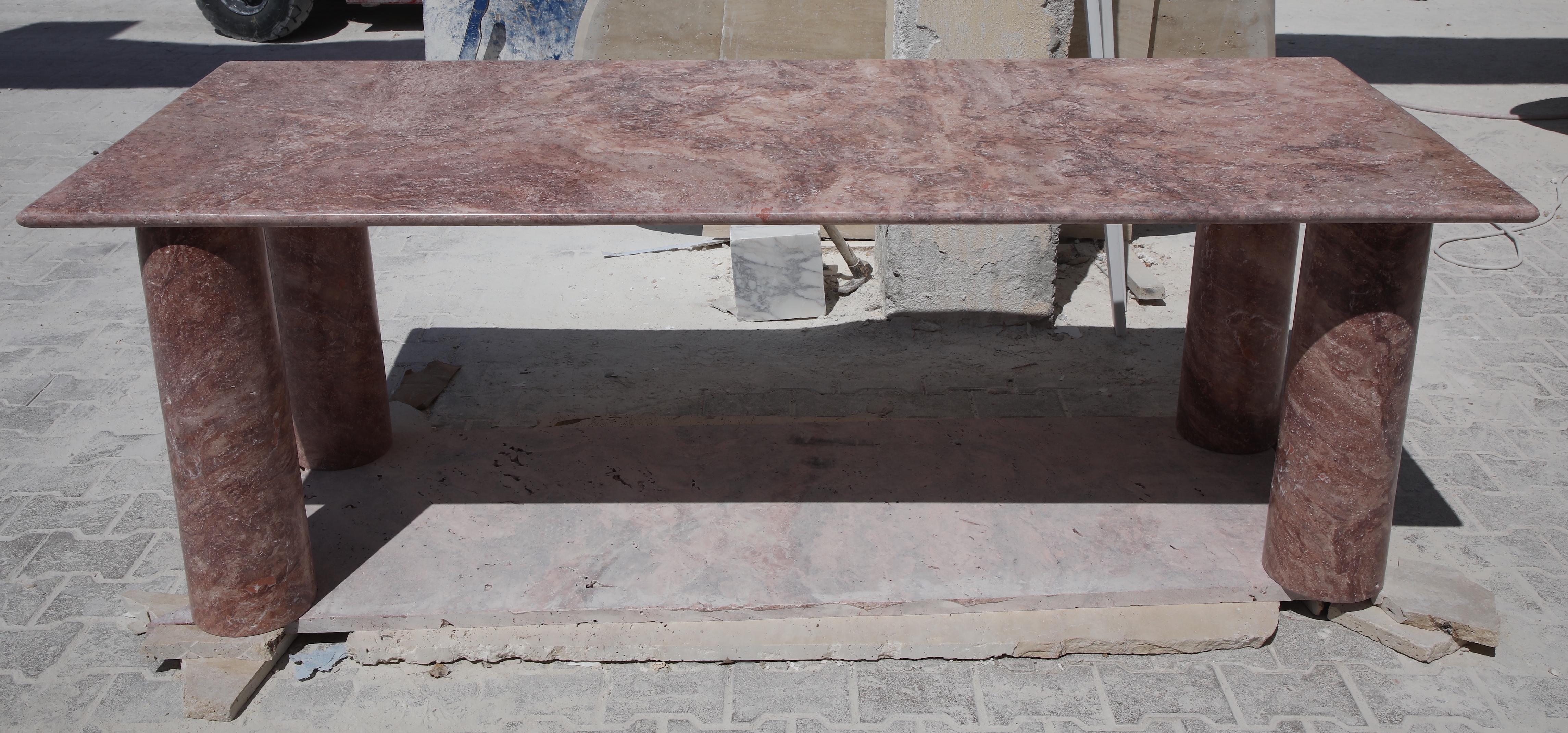 Questo tavolo minimalista è realizzato in travertino rosso di alta qualità, con un piano dai bordi curvi che poggia elegantemente su quattro colonne cilindriche, dando a questo tavolo un aspetto scultoreo. 

Ispirandosi ai pezzi vintage di Mario