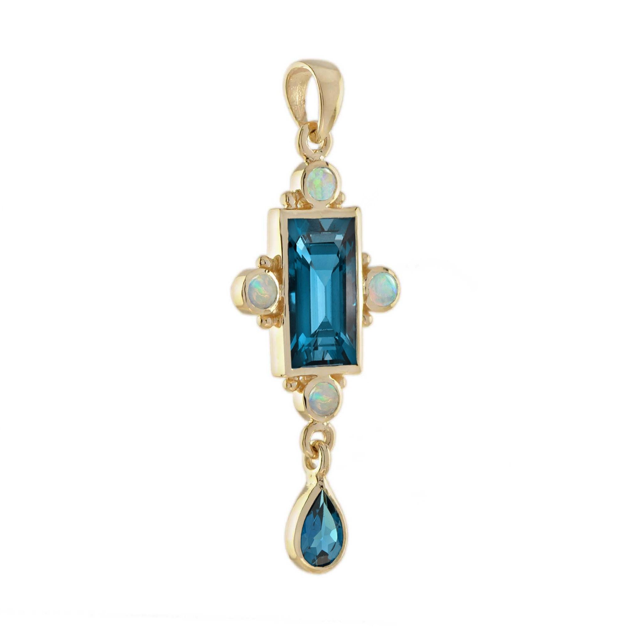 Mit einem tiefgrünen Londoner Blautopas in einer Lünettenfassung ist dieser Anhänger ein einfacher, aber auffälliger Stil. Der Stein ist mit kleineren Tropfen aus blauem Topas und rundem Opal akzentuiert. Dieses Stück ist perfekt, um es allein zu