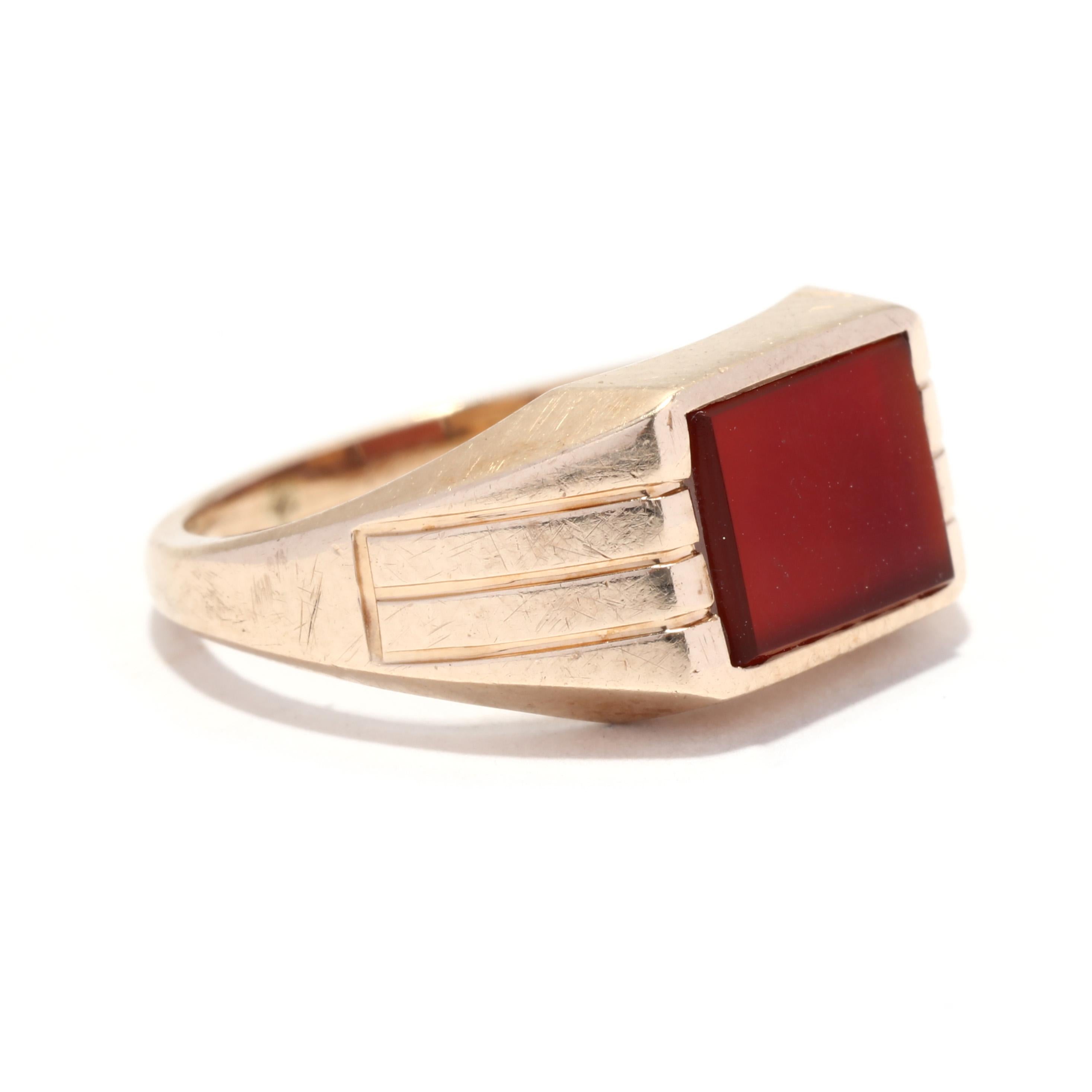 A vintage 10 karat yellow gold carnelian rectangle signet ring. This gent's pinky ring features a rectangular tablet carnelian set in a tapered signet ring with ridged detailing on the band.

Stones:
- carnelian, 1 
- rectangular tablet
- 8 x 6