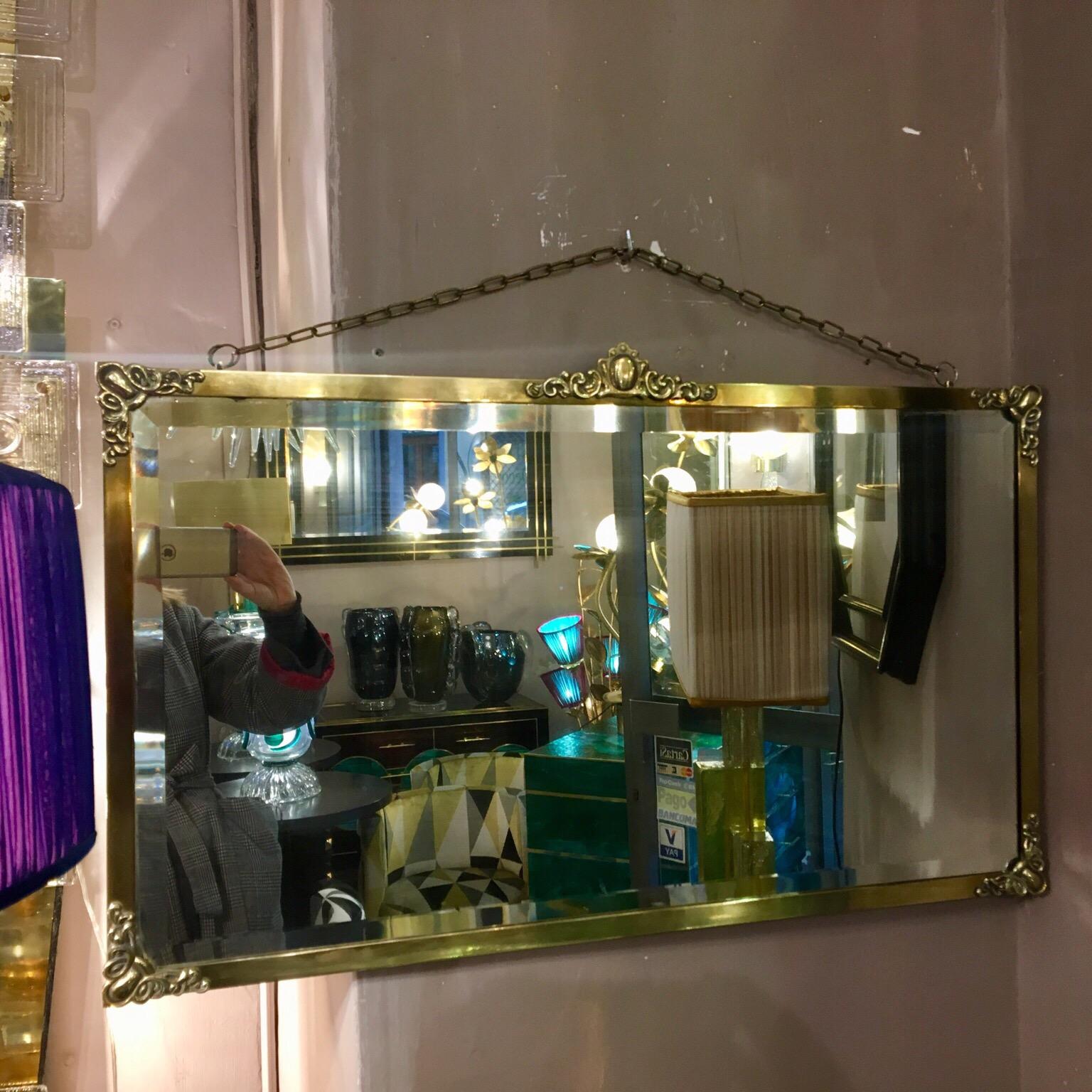 Rectangular Art Nouveau mirror with brass frame and brass friezes. Beveled original mirror, brass chain to hang the mirror.