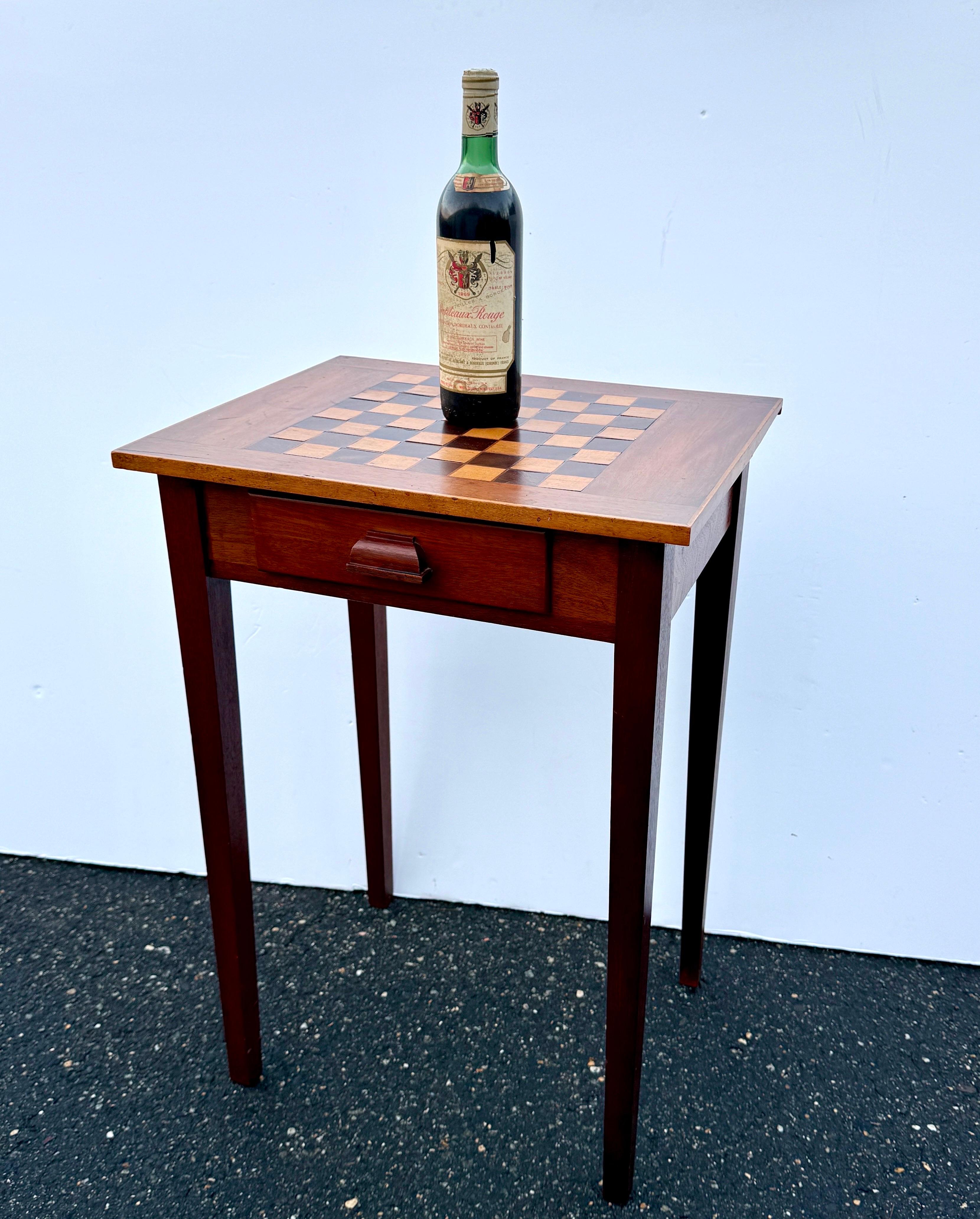 Table de jeu classique avec un échiquier intégré en bois fruitier incrusté sur la surface. La table en bois comporte un seul tiroir avec une poignée pour ranger les pièces d'échecs. La table a été conçue avec un sens de la grâce et de la