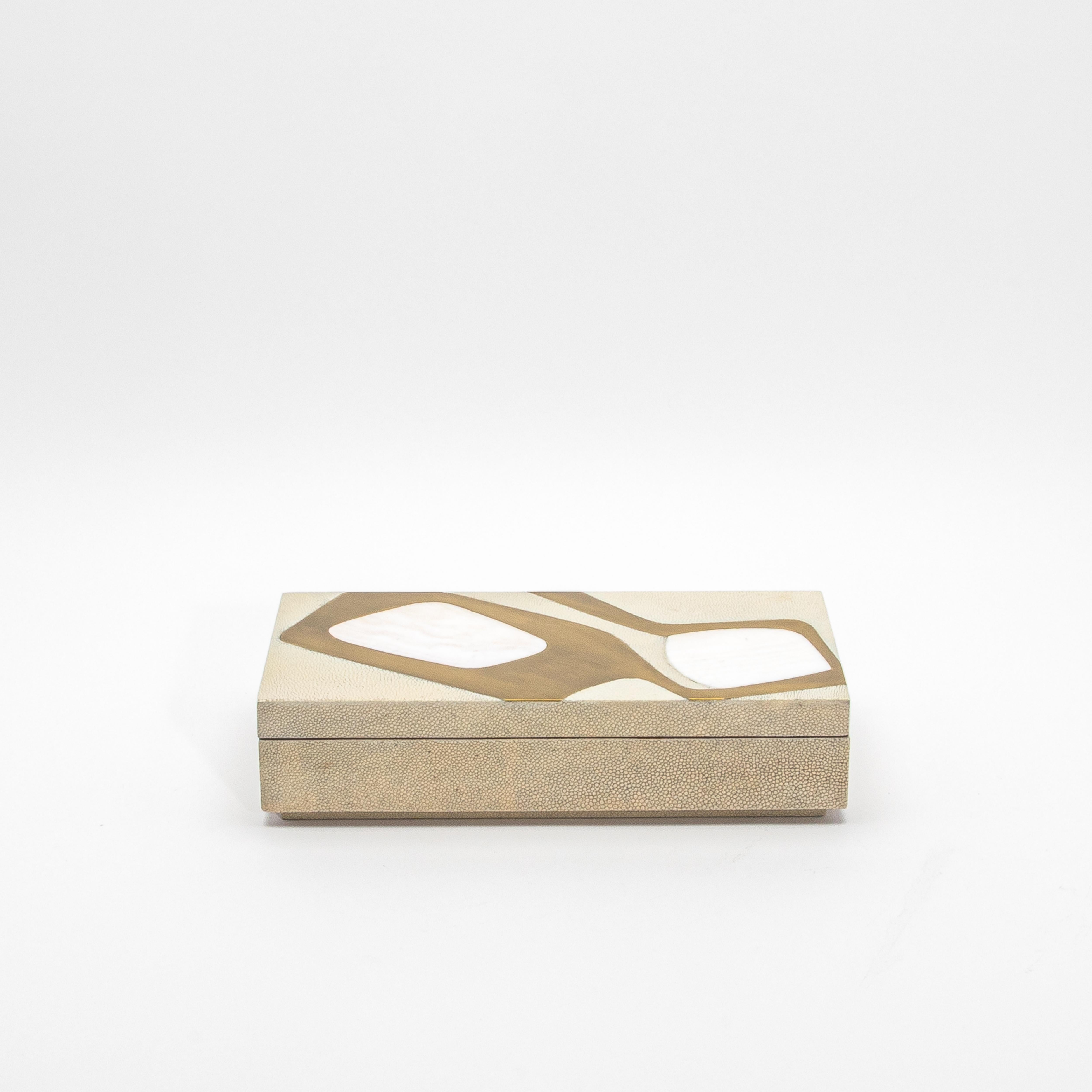 Esta exquisita caja rectangular está elaborada con maestría a partir de piel de zapa antigua, mostrando un exclusivo motivo cosmos que combina con elegancia el diseño moderno con el lujo clásico. Presenta intrincadas incrustaciones de nácar y latón,