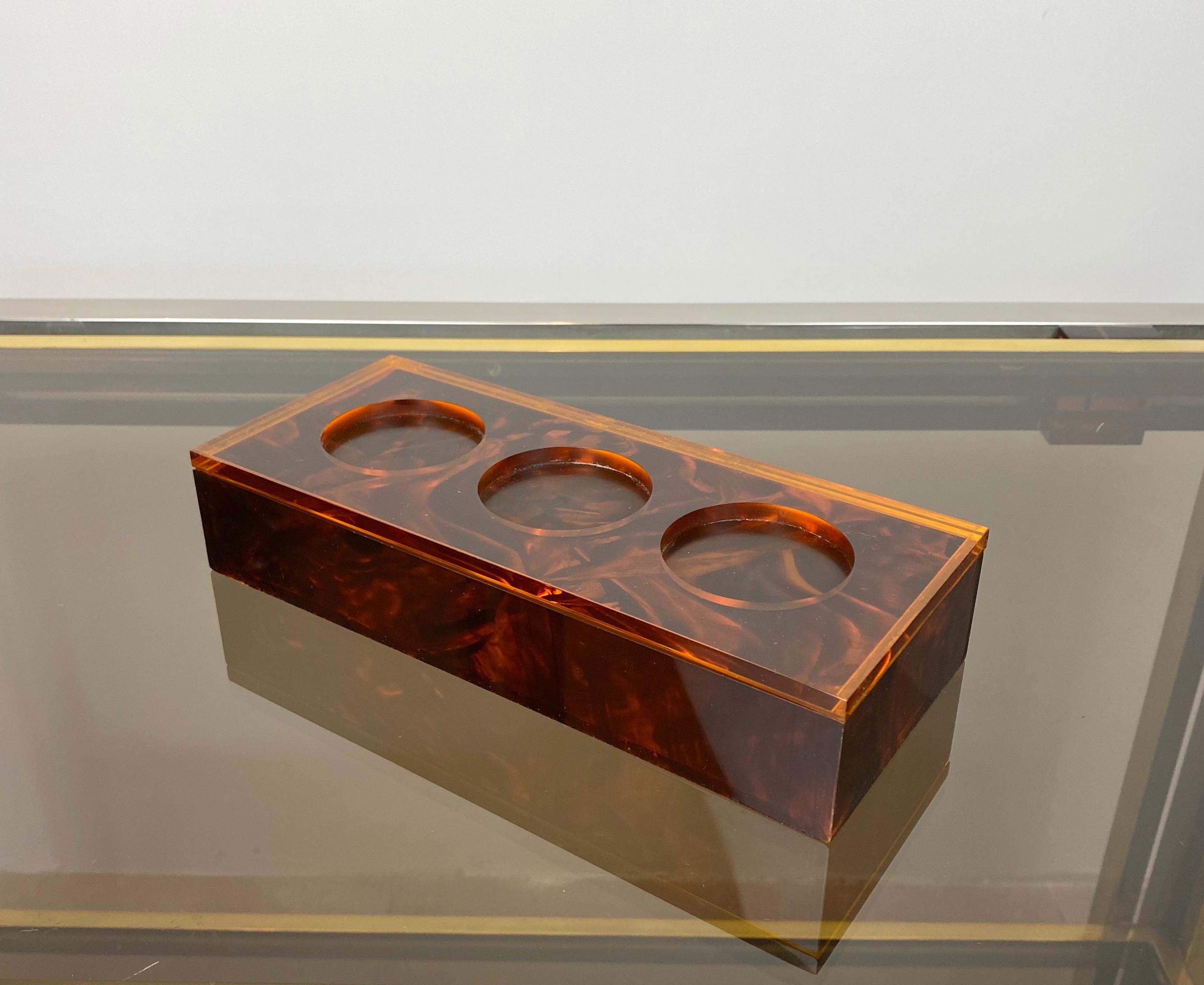 Rectangular box in Lucite tortoiseshell effect with three hollow circles on the top. Made in Italy, 1970s.