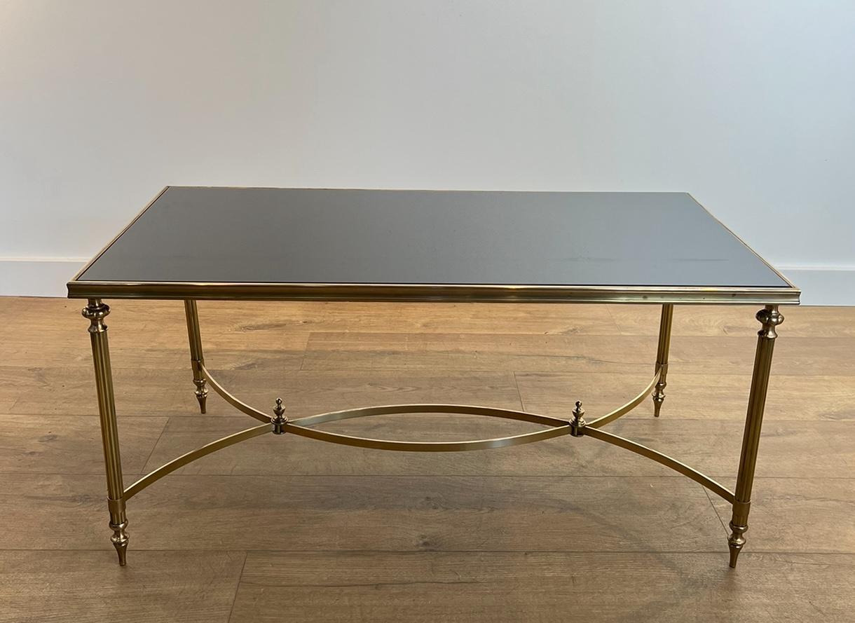 Cette très belle et élégante table basse rectangulaire est en laiton avec un plateau en verre laqué noir. Il s'agit d'un ouvrage français de la Maison Jansen. Circa 1940