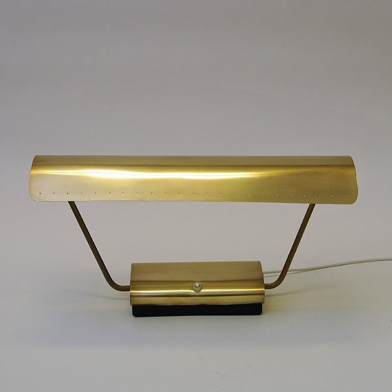 Lovely Norwegian rectangular shaped brass table/desklamp made by Philips in the 1950s. Brass shade and body with a white metal inner shade. Light switch located on the brass base. The massive shade are perforated with small holes to let the light
