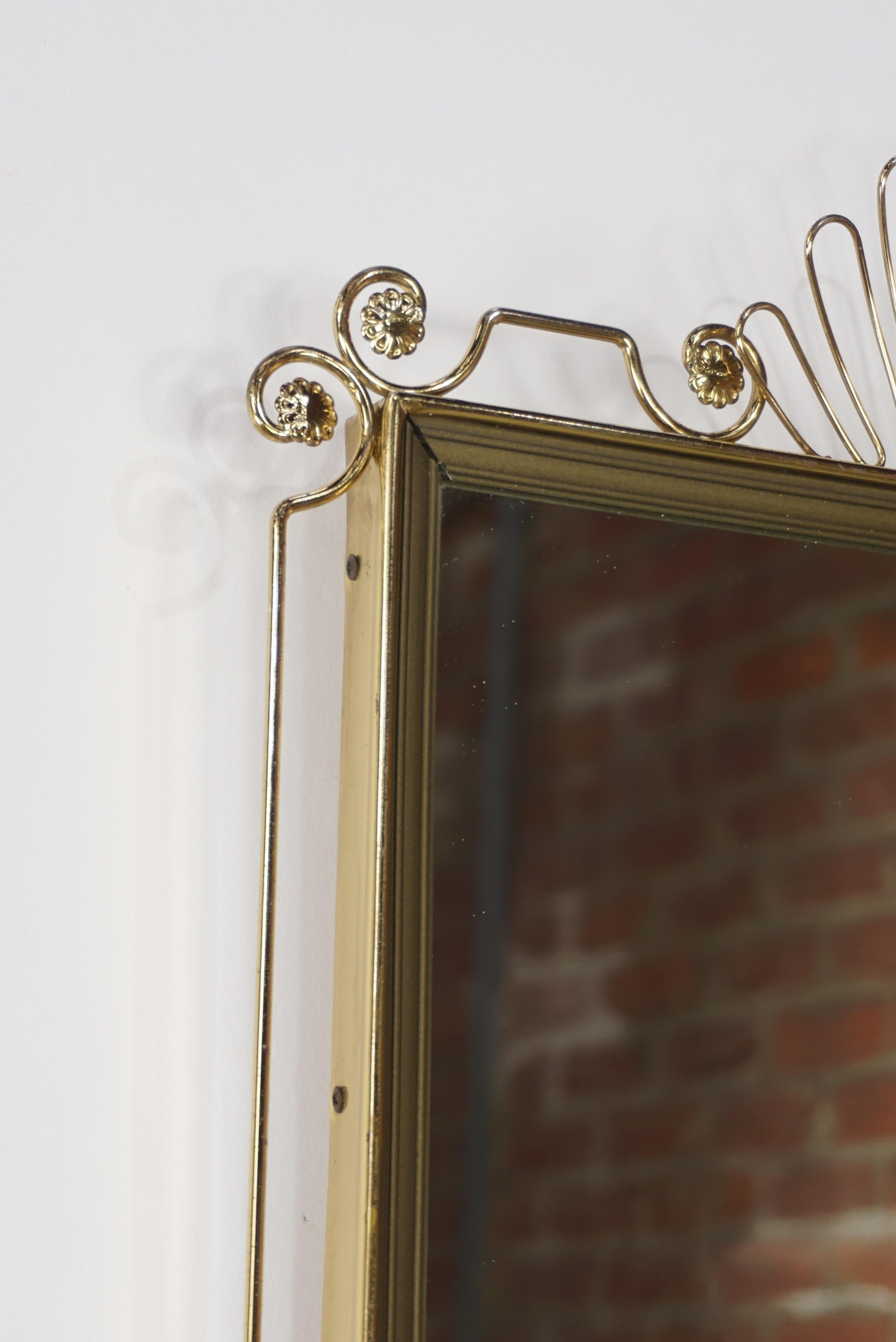 Rectangular brass metal mirror 1950s design with fine brass scrolls and trappings bordering the whole frame.
