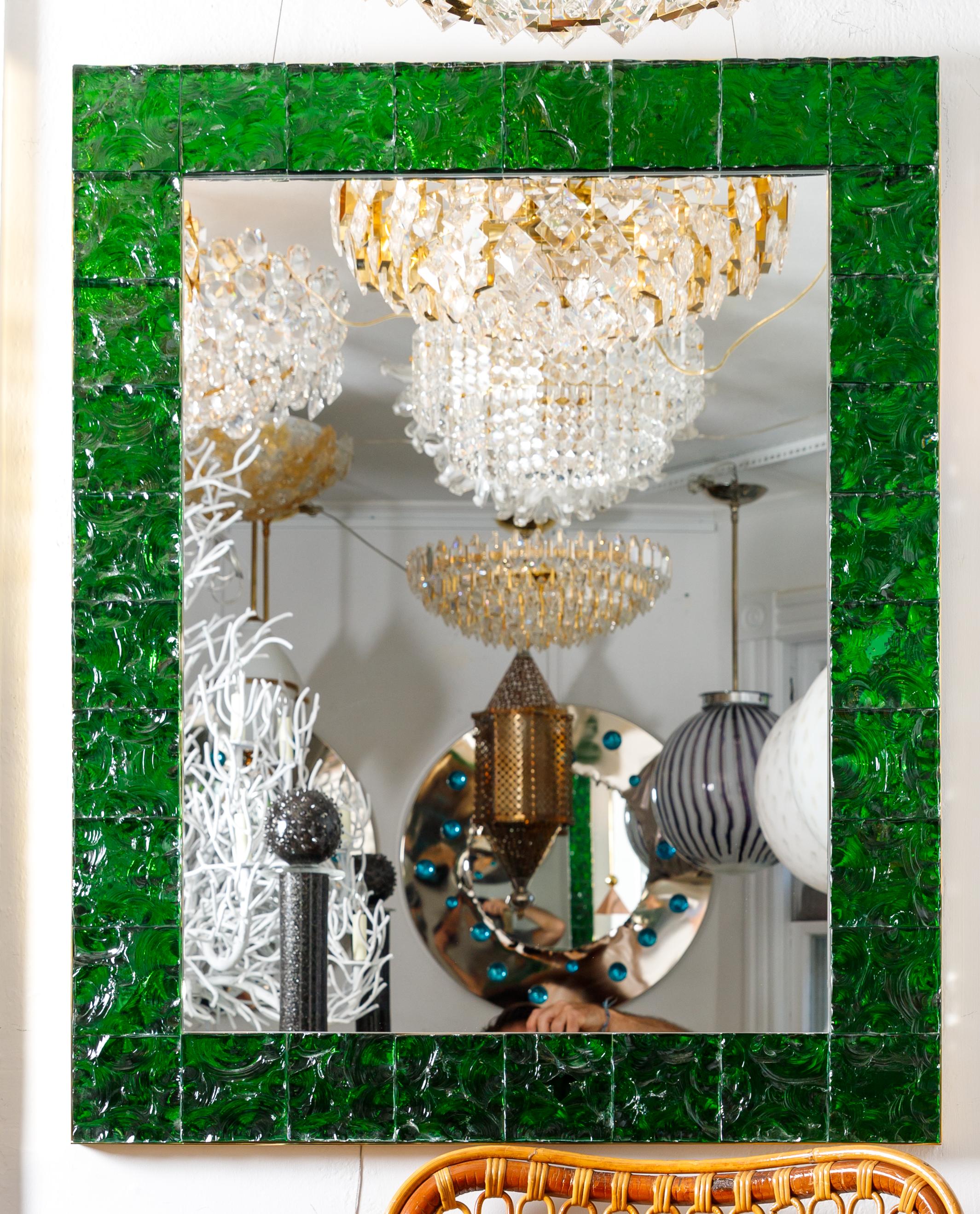 Rectangular brass mirror featuring a surround of green 