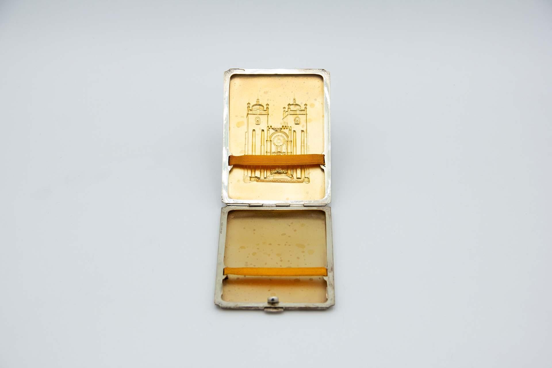 Descripción: Pitillera de plata cepillada, de forma rectangular, con relieves que representan la catedral de Oporto. Metal: Silver. Origen: Portugués. Marca: Cabeza de águila. Peso: 132,82 gramos. Dimensiones: 11,4 cm x 1,3 cm. Contenido: 833/1000.