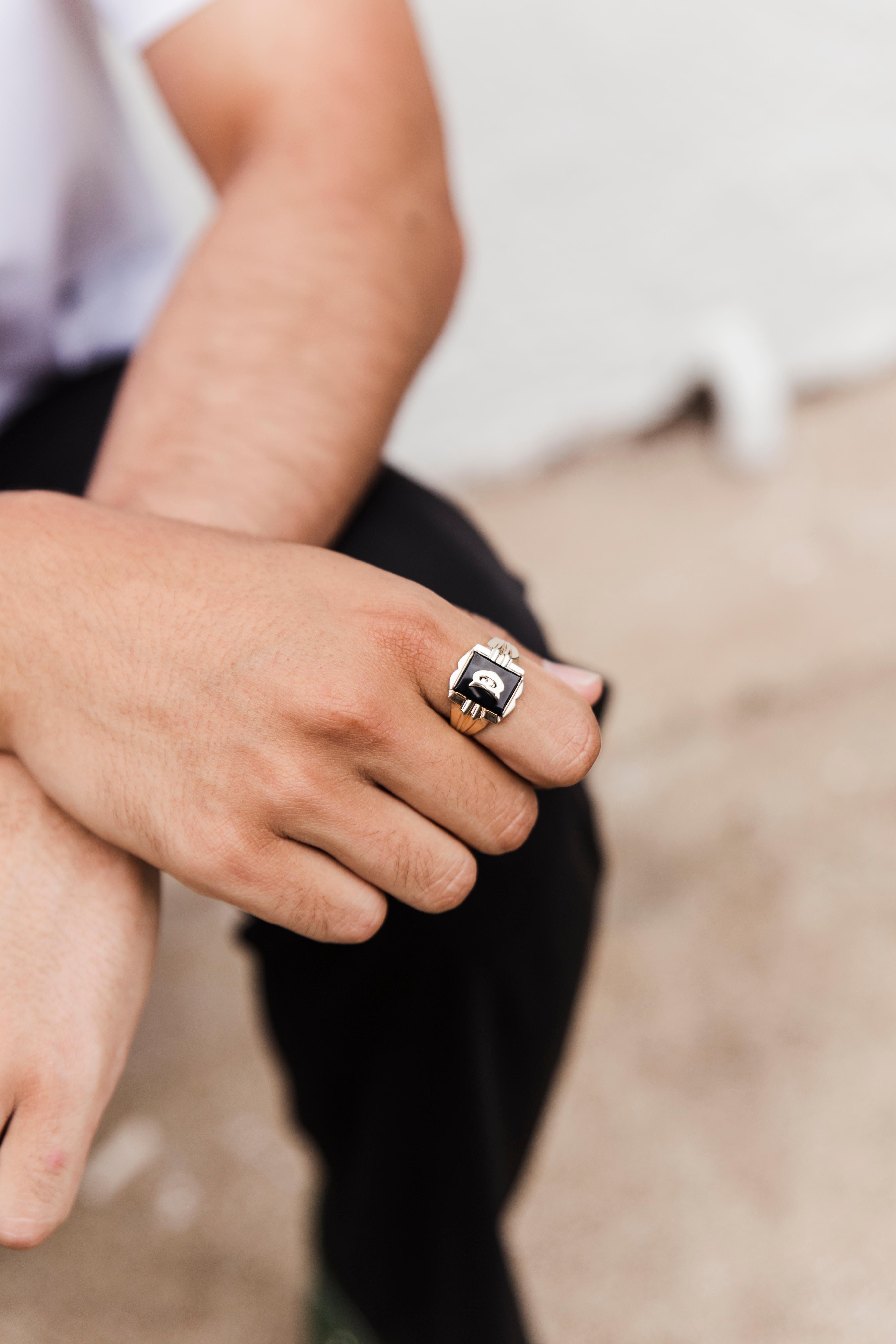 Forged in 9 carat yellow gold, this debonair vintage signet ring features a handsome buff top black onyx embellished with a yellow gold letter D and set in an ornate bar setting.  We have named this dapper vintage piece The Sly Ring, a suave and